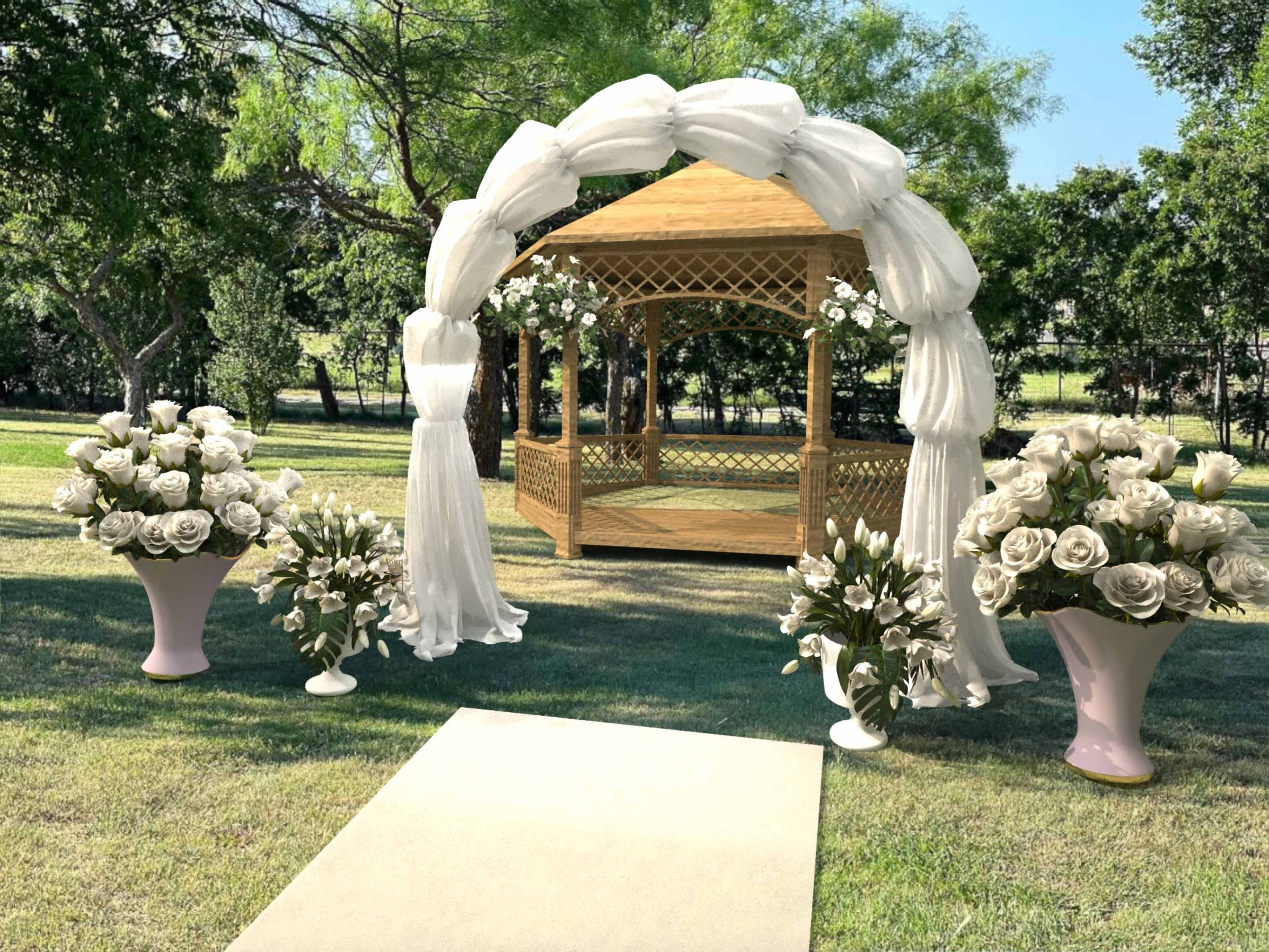 A decorated gazebo is set in a grassy area, flanked by large flower arrangements and a white walkway leading to it.