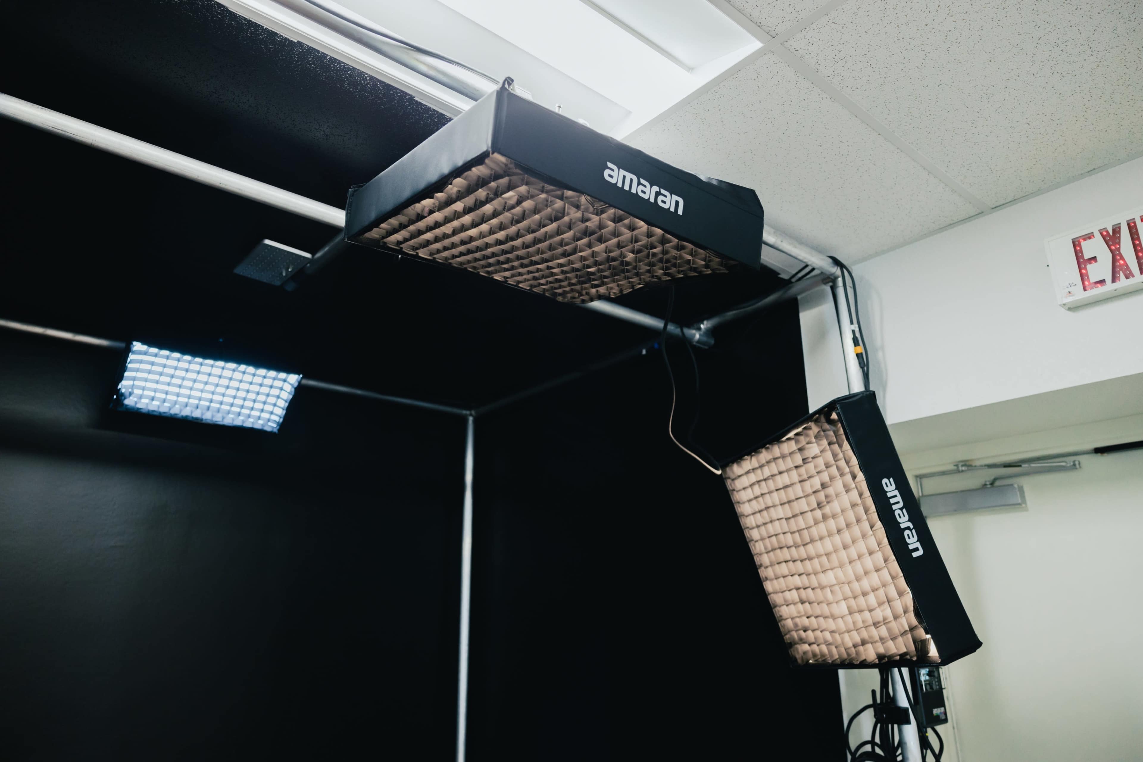 Three light fixtures mounted on a ceiling, providing illumination in a dark room.