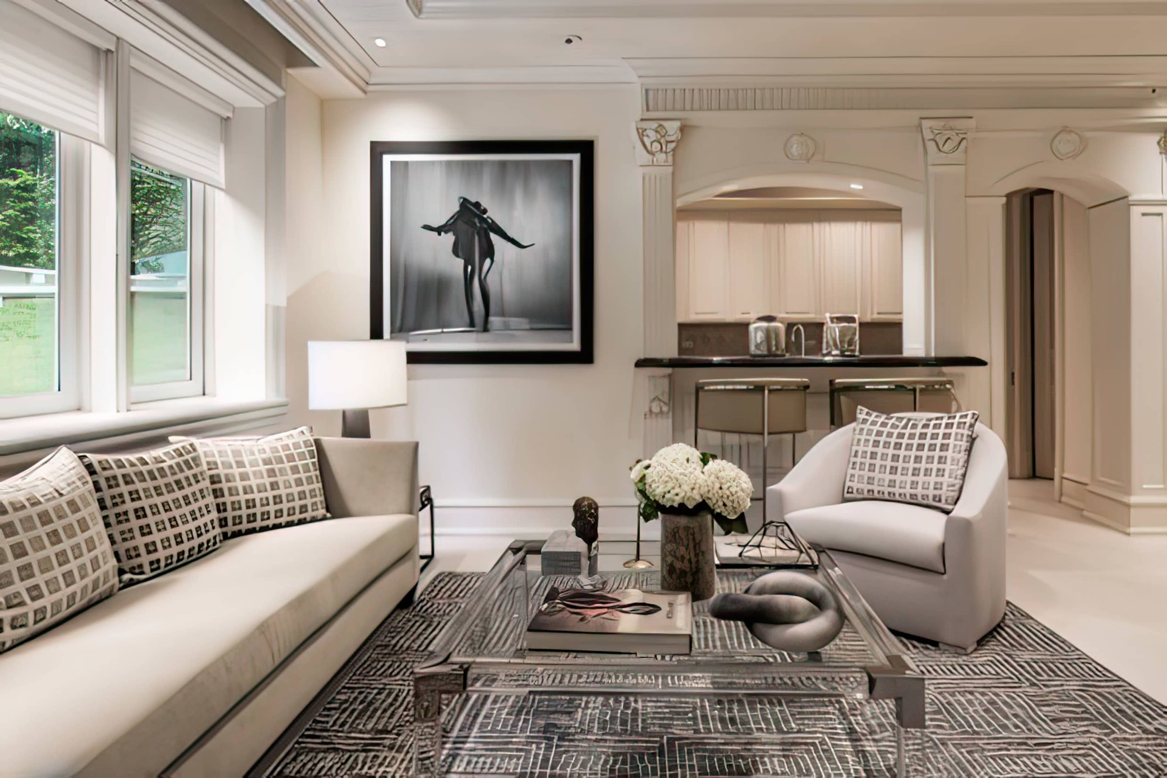 The image shows a modern living room with a grey sofa, a round chair, a coffee table, and a large black-and-white artwork on the wall.
