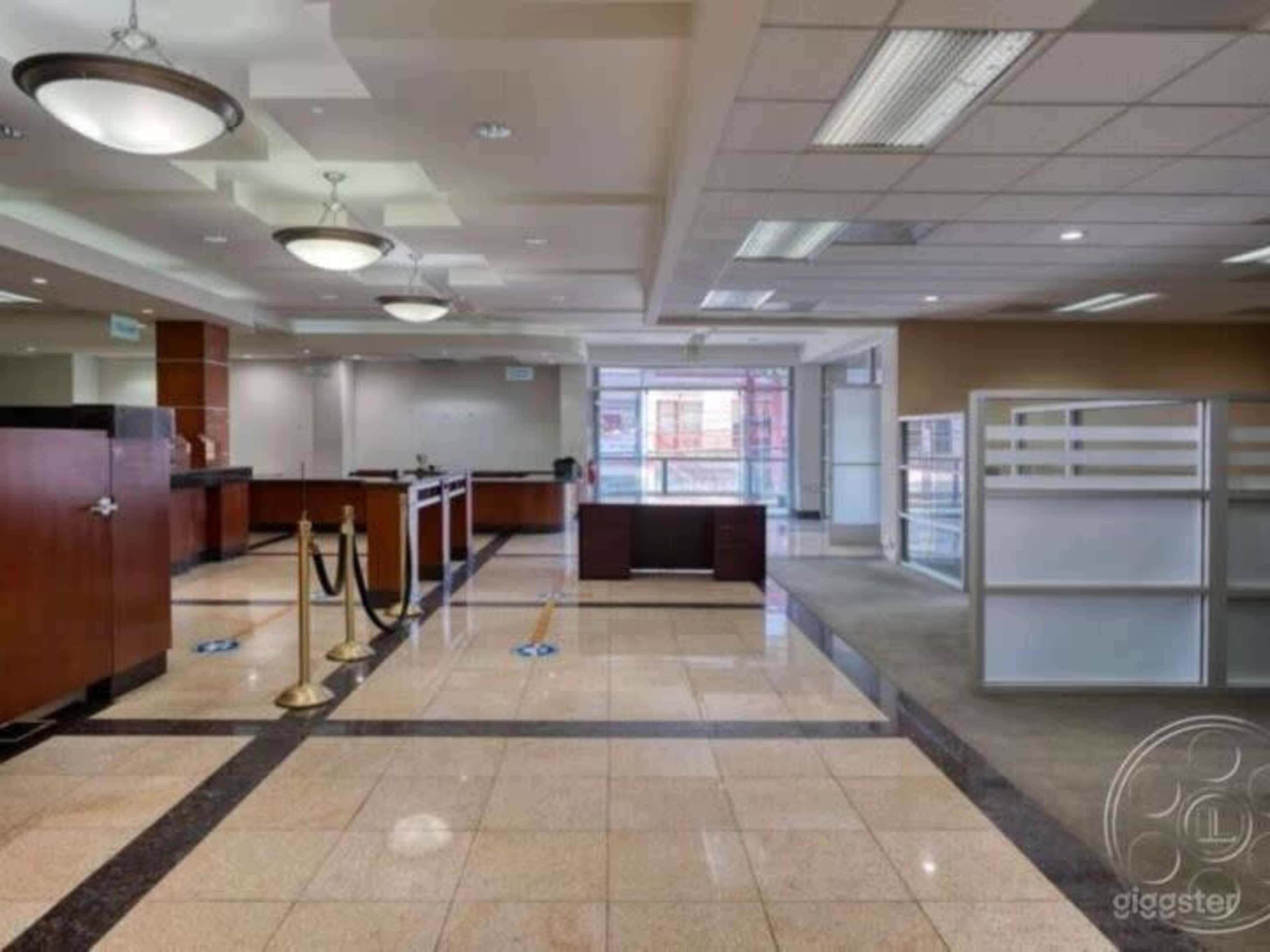 The image shows a modern office interior with a reception area featuring a front desk, seating, and large windows.