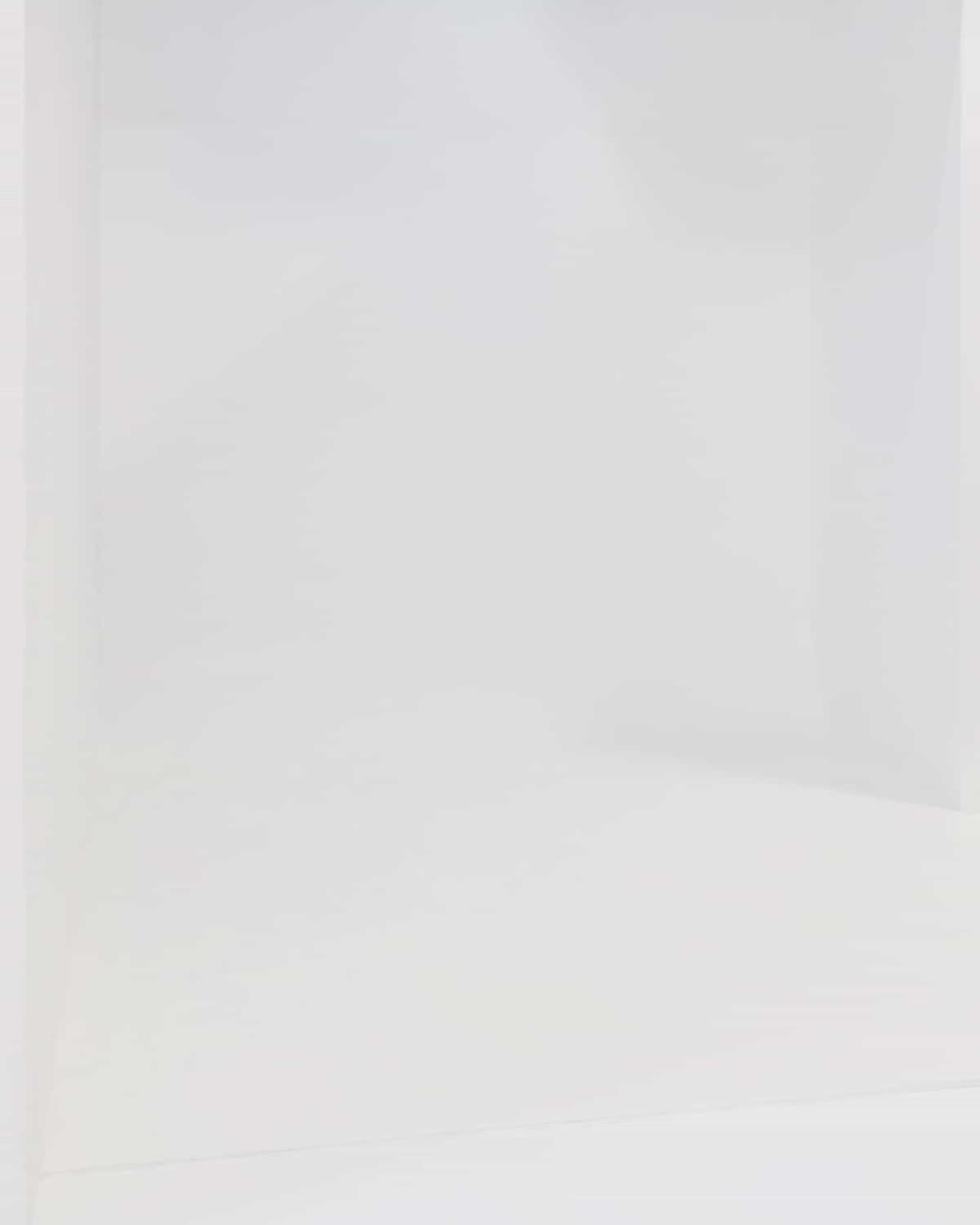 The image shows a minimalistic, empty room with white walls and a white floor.