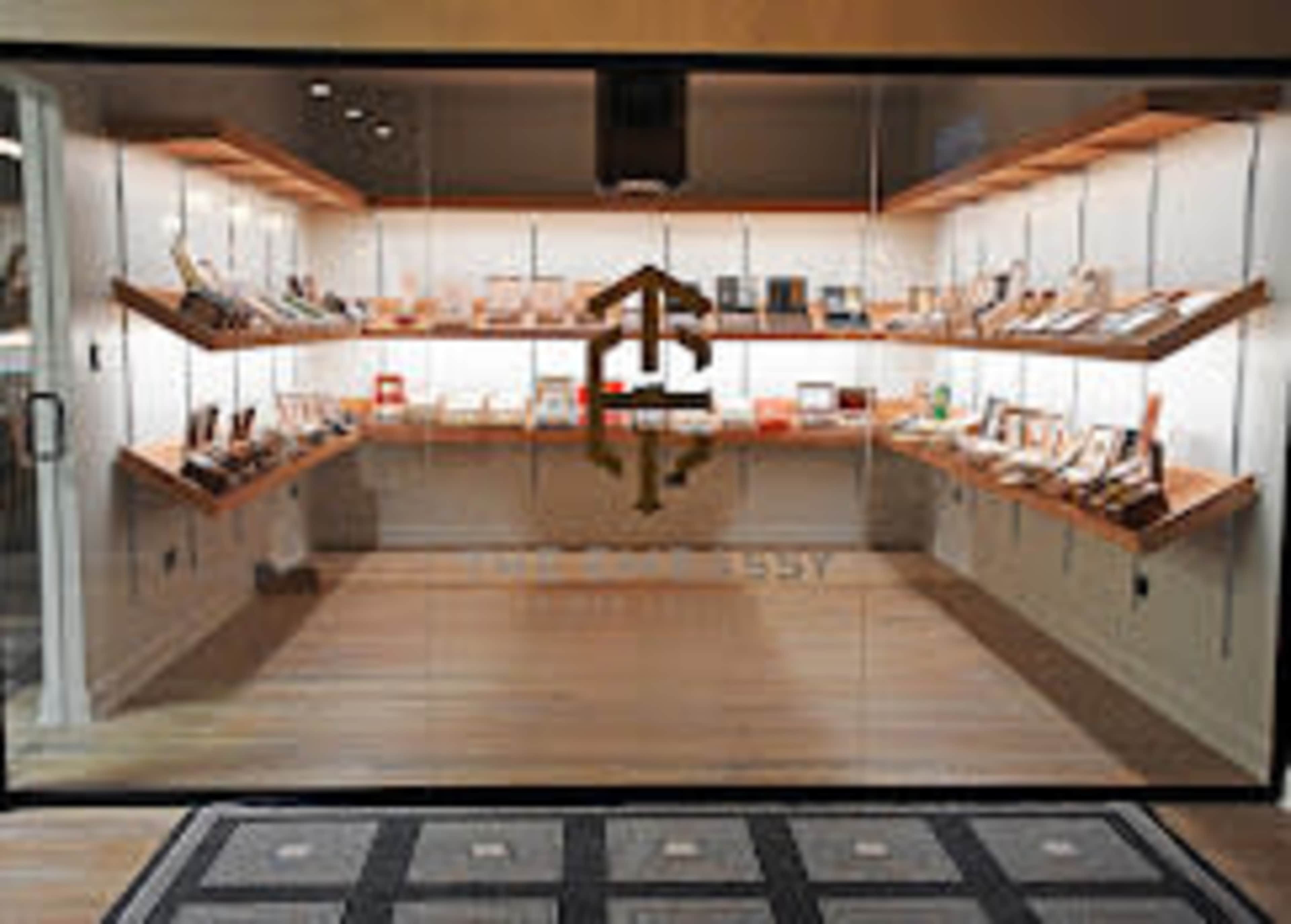 The image shows a retail store display featuring shelves filled with various electronic devices and accessories, all arranged neatly within a glass-fronted storefront.