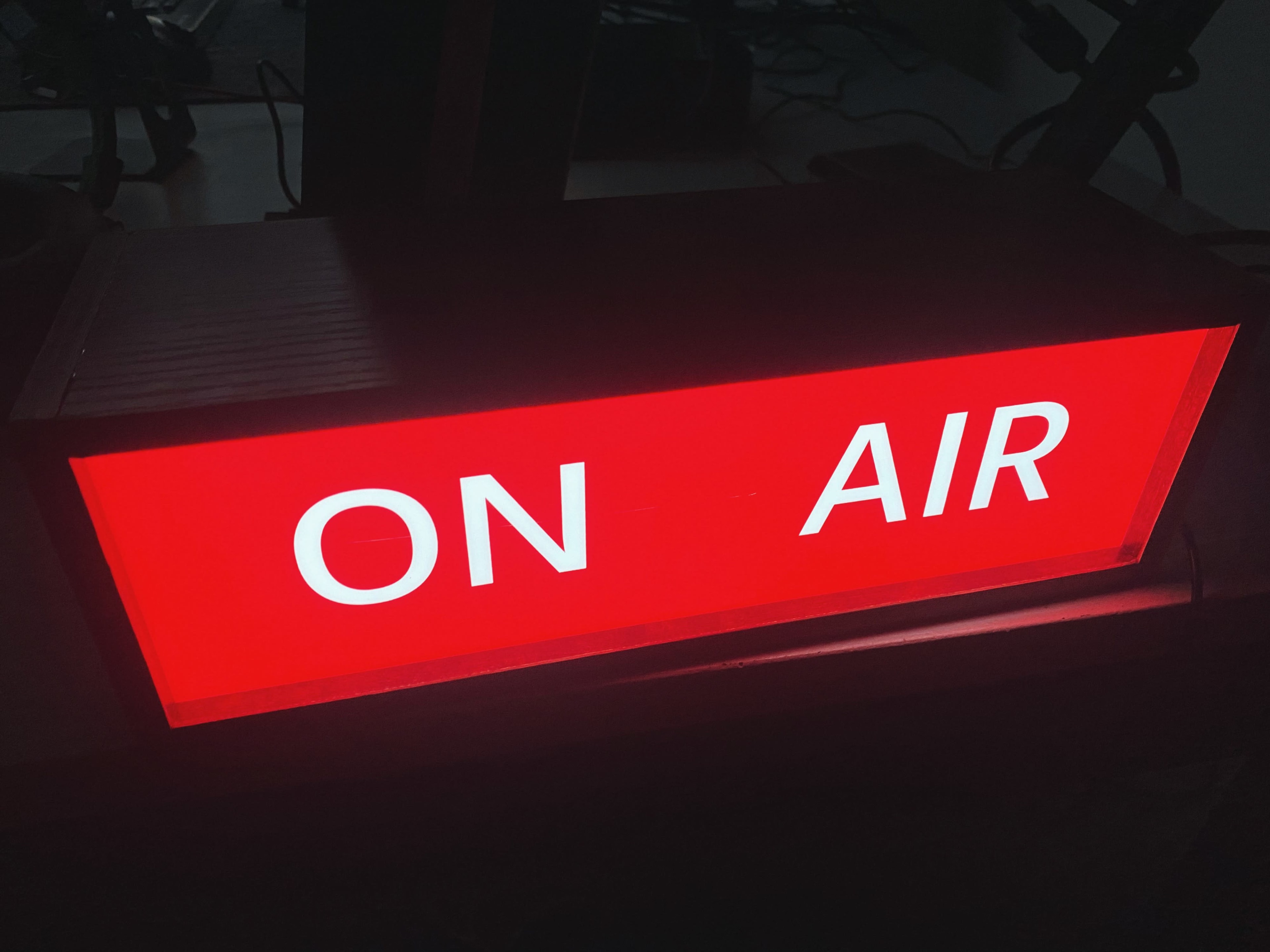 A red illuminated "ON AIR" sign is displayed prominently on a surface.