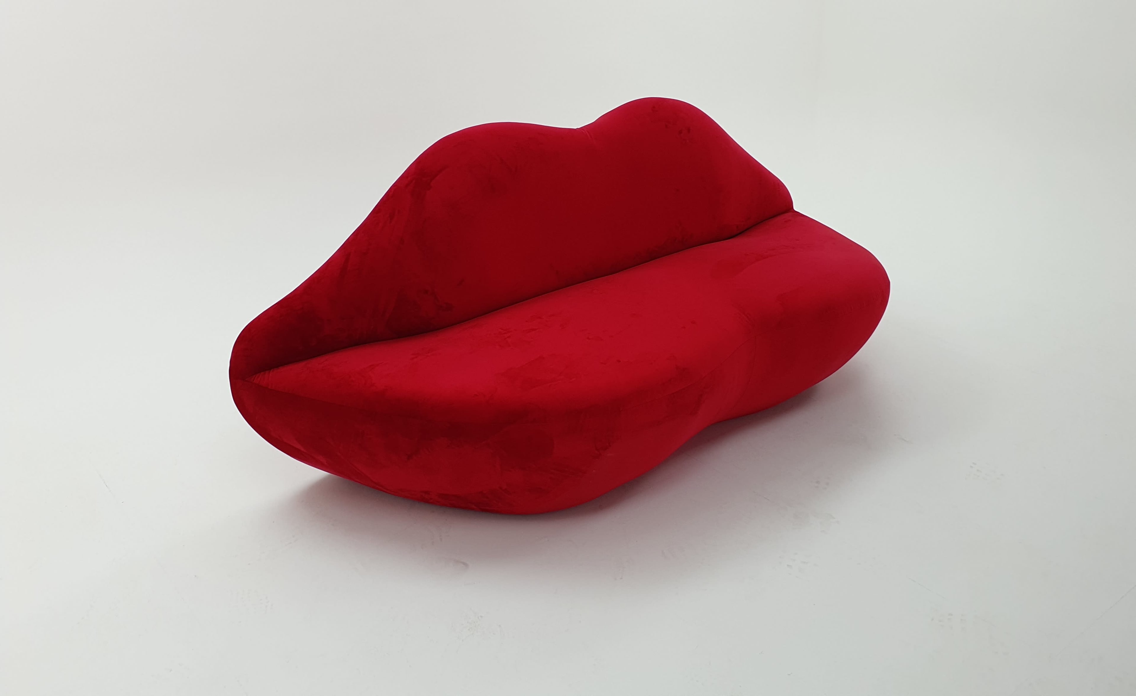 The image features a bright red sofa designed to resemble a pair of lips.