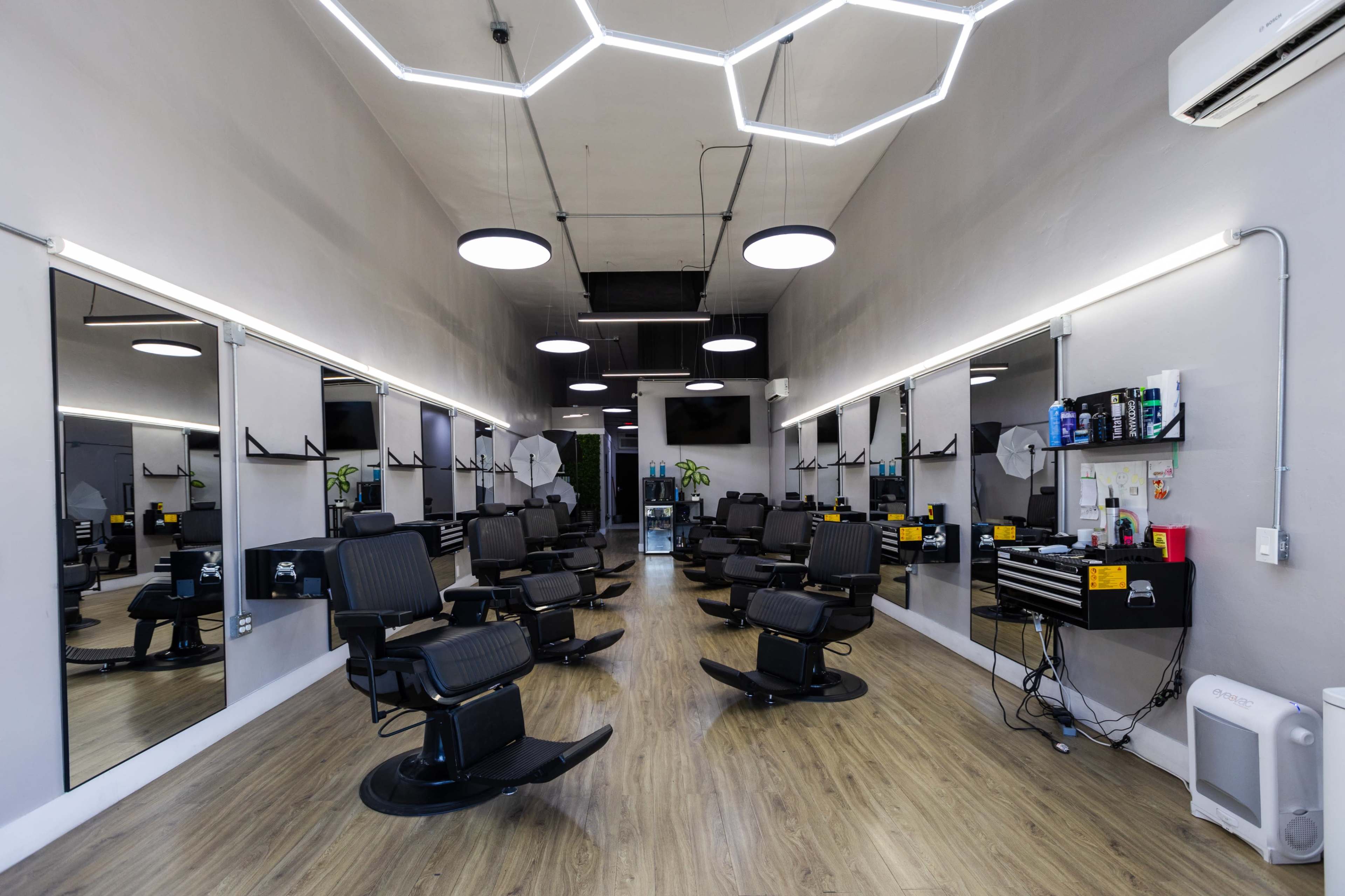 The image shows a modern hair salon interior with multiple styling chairs, large mirrors, and contemporary lighting fixtures.