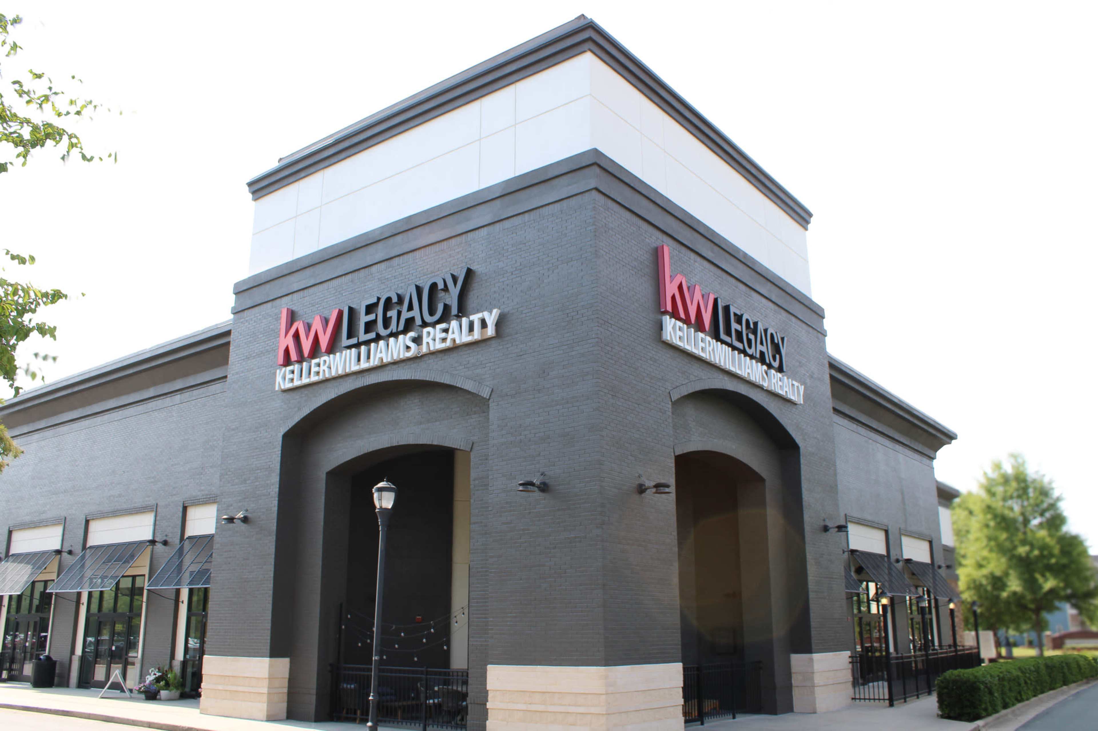 The image shows a modern commercial building featuring the Keller Williams Realty logo prominently displayed on its exterior.