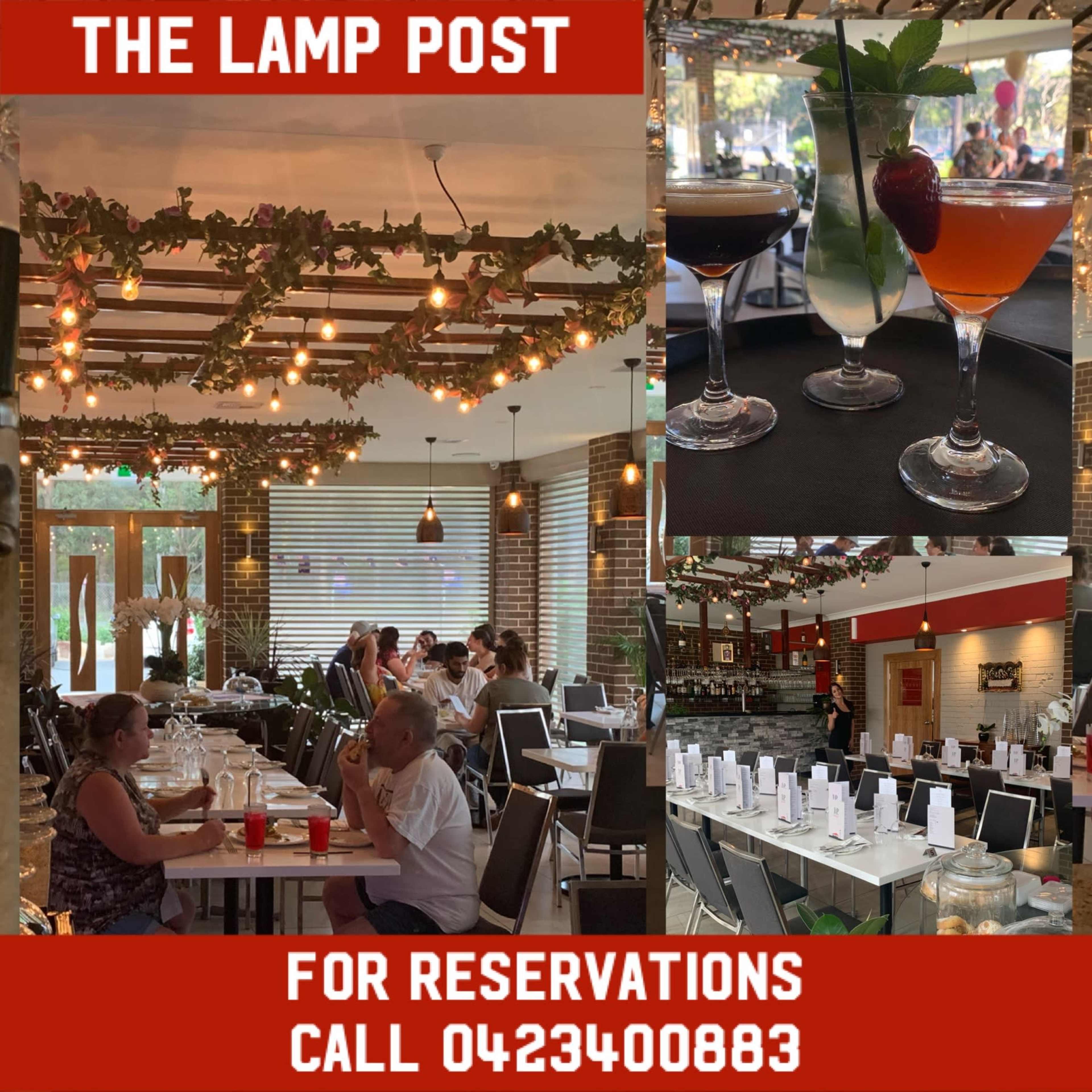 The interior of a restaurant called The Lamp Post, featuring tables set for dining, decorative lighting, and various cocktails displayed on a table.