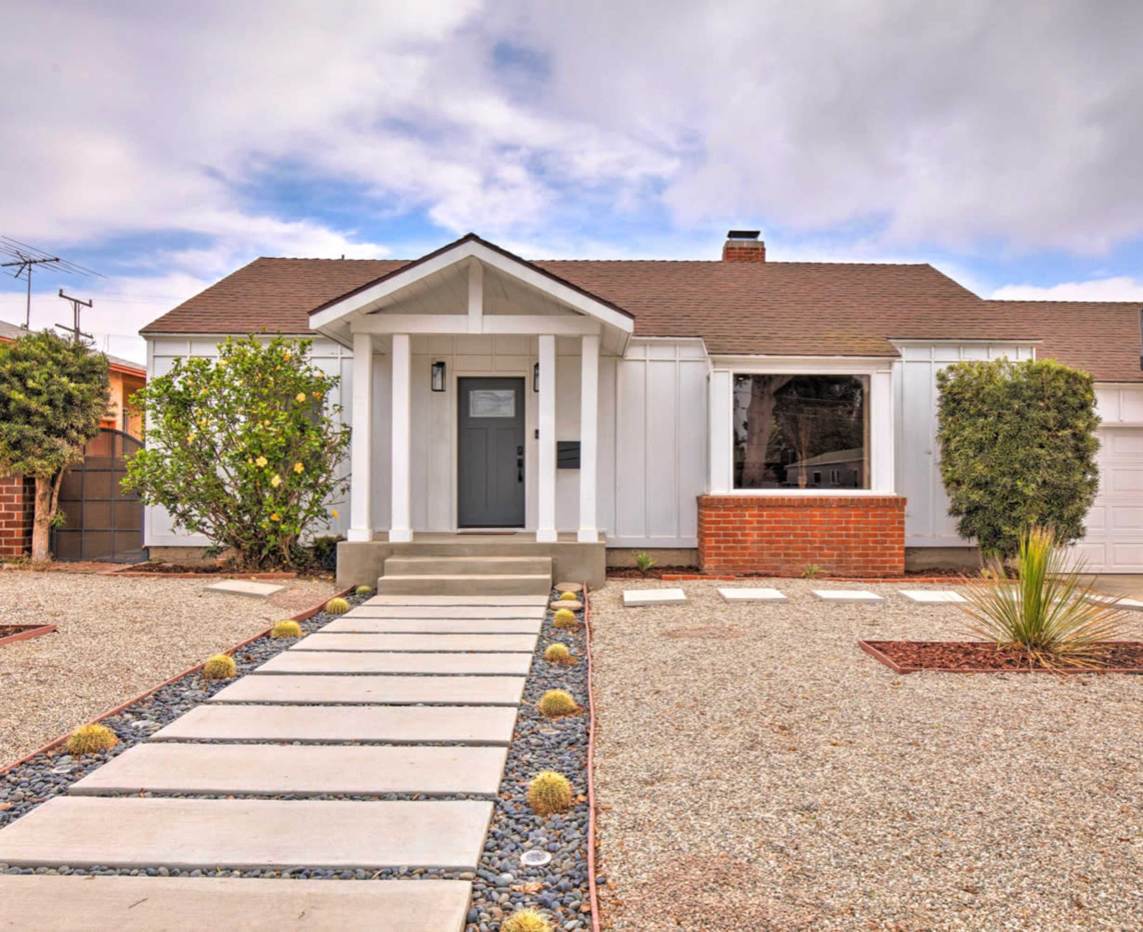 A single-story house with a front porch, gravel landscaping, and a walkway leading to the entrance.