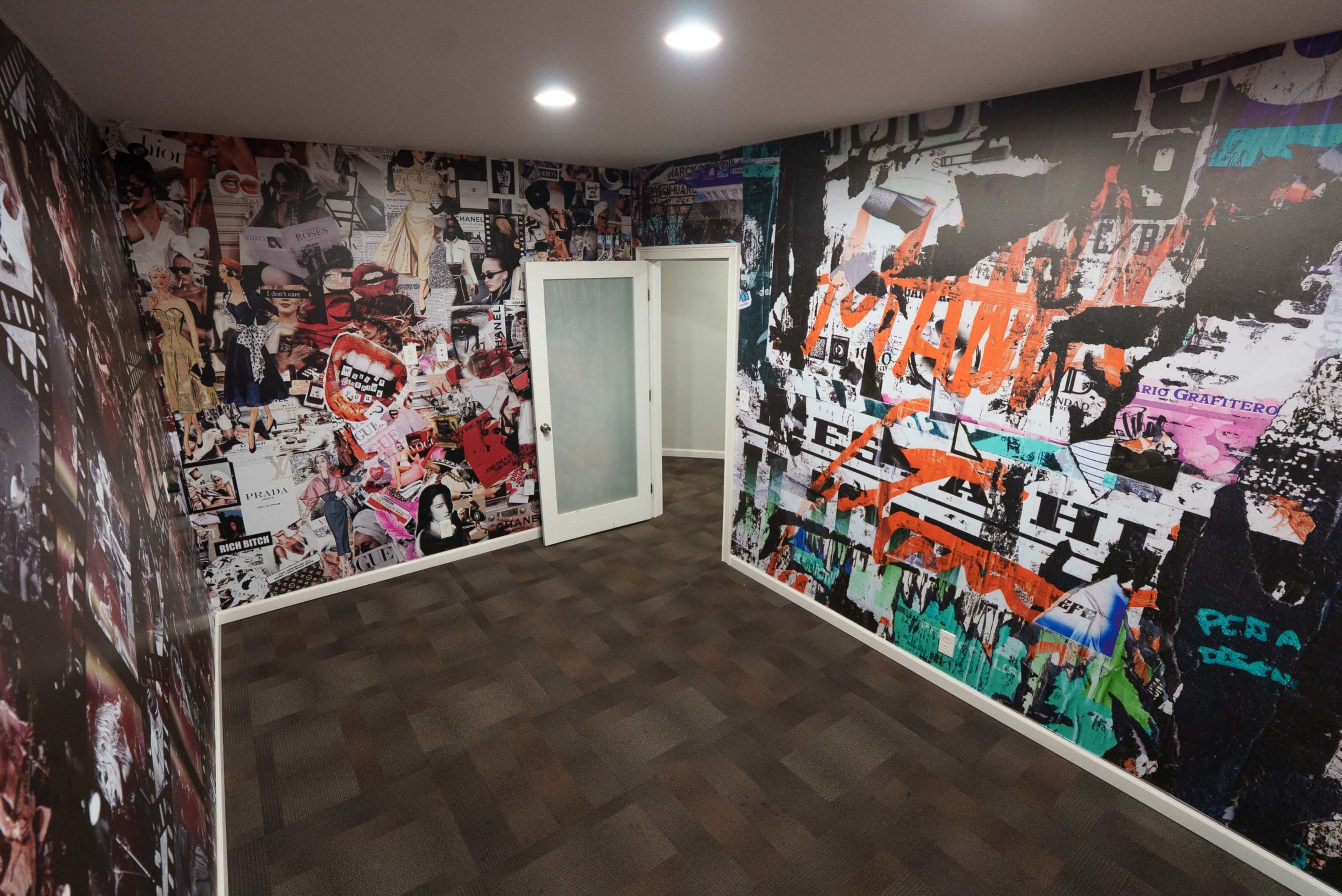 The image shows a room with walls covered in vibrant, collage-style artwork featuring various images and designs, and a white door in the background.