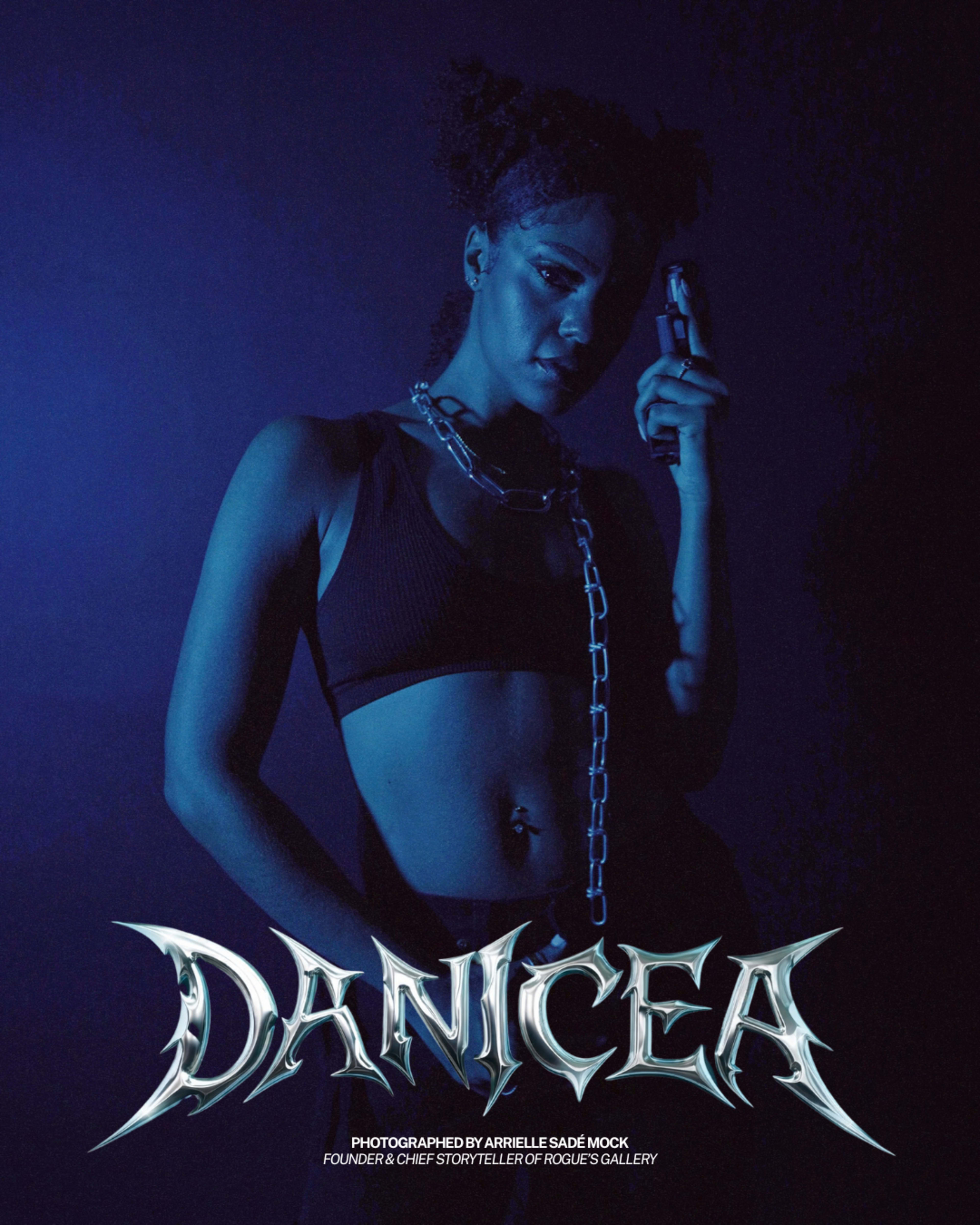 A person stands in a dark setting holding a gun, illuminated by a blue light with the name "DANICEA" prominently displayed below.
