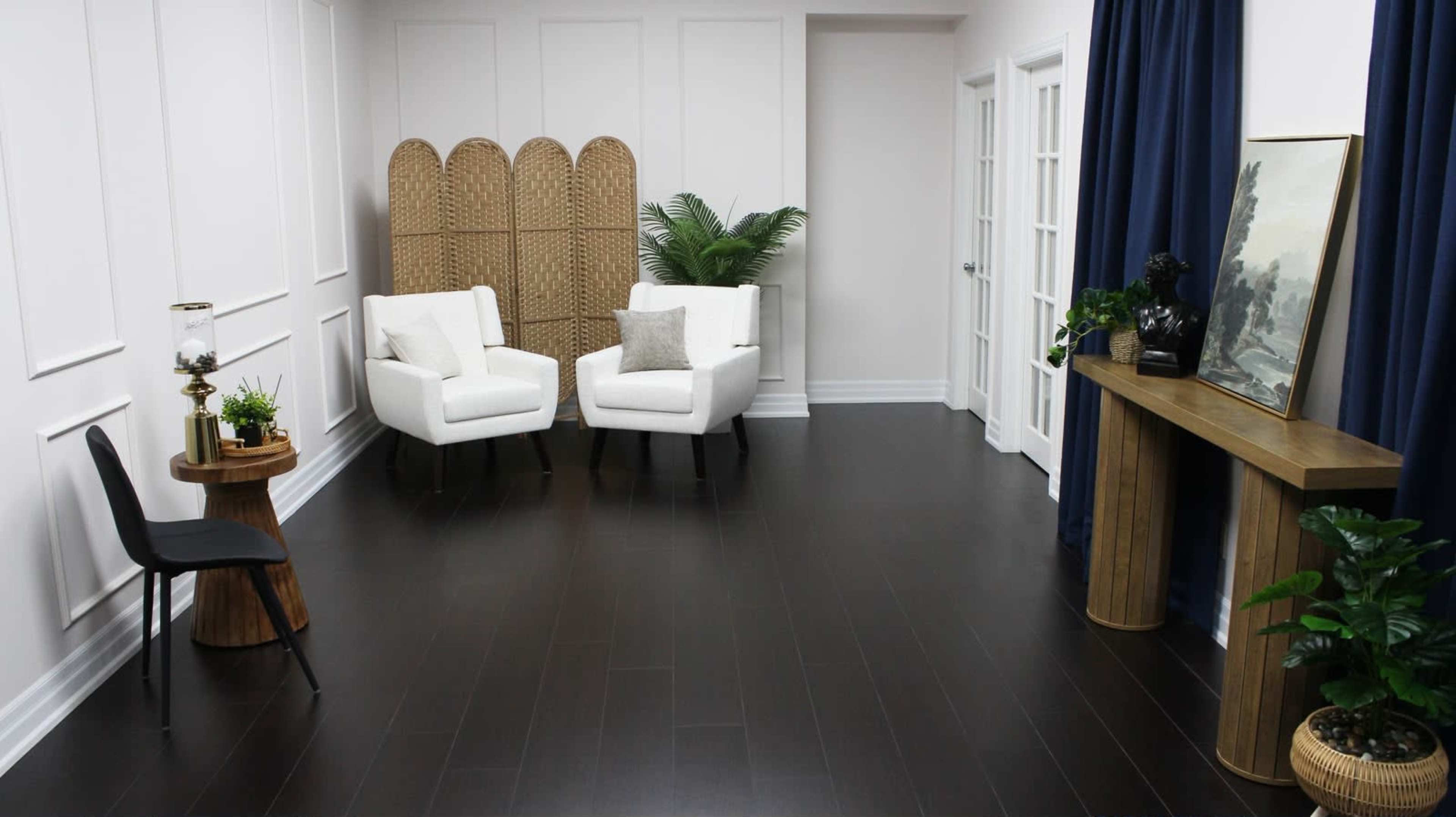 The image shows a modern, minimalist interior design featuring two white chairs, a wooden side table, a potted plant, and decorative elements against a light-colored wall.