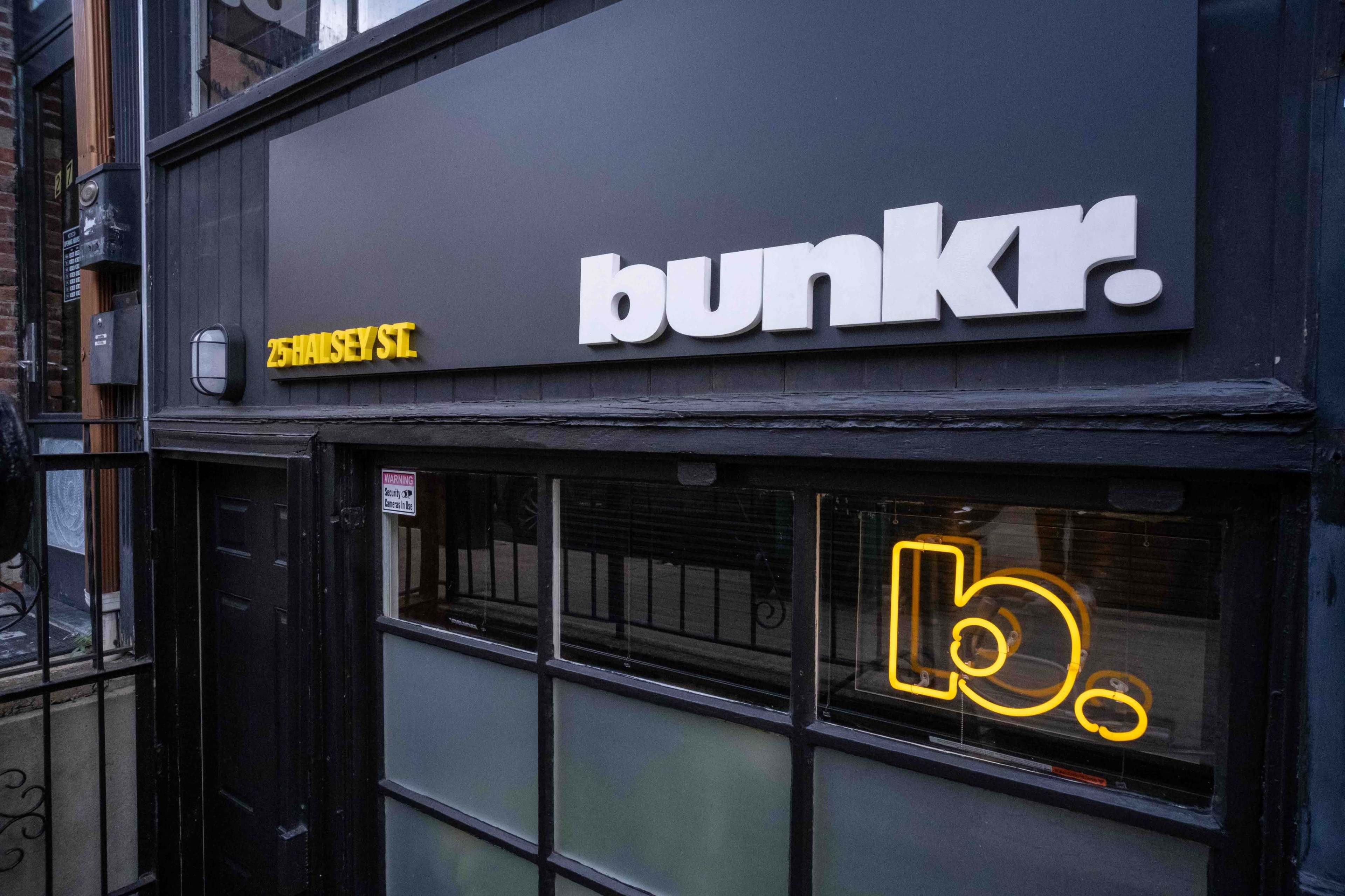 A storefront with the name "bunkr" displayed prominently on a black background, featuring a lit neon sign and an address that reads "25 Hanley St."