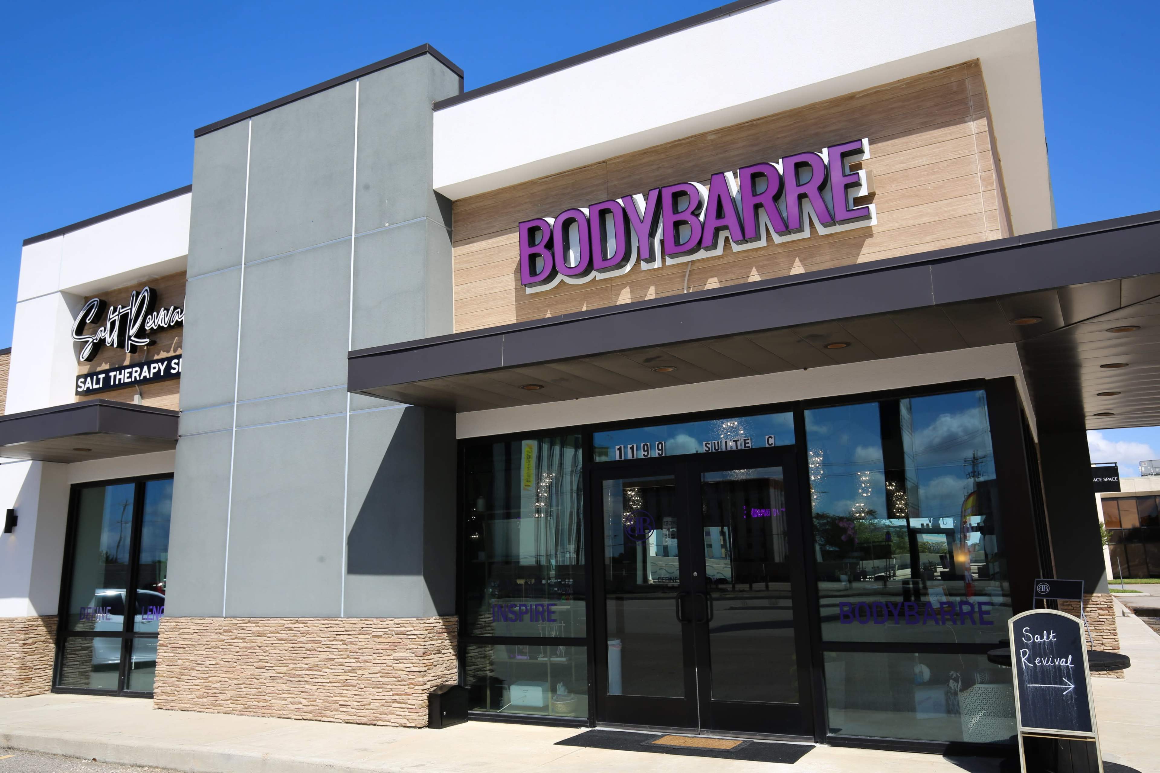 The image shows a commercial building featuring a storefront for "BodyBarre" and a side entrance to a salt therapy studio.