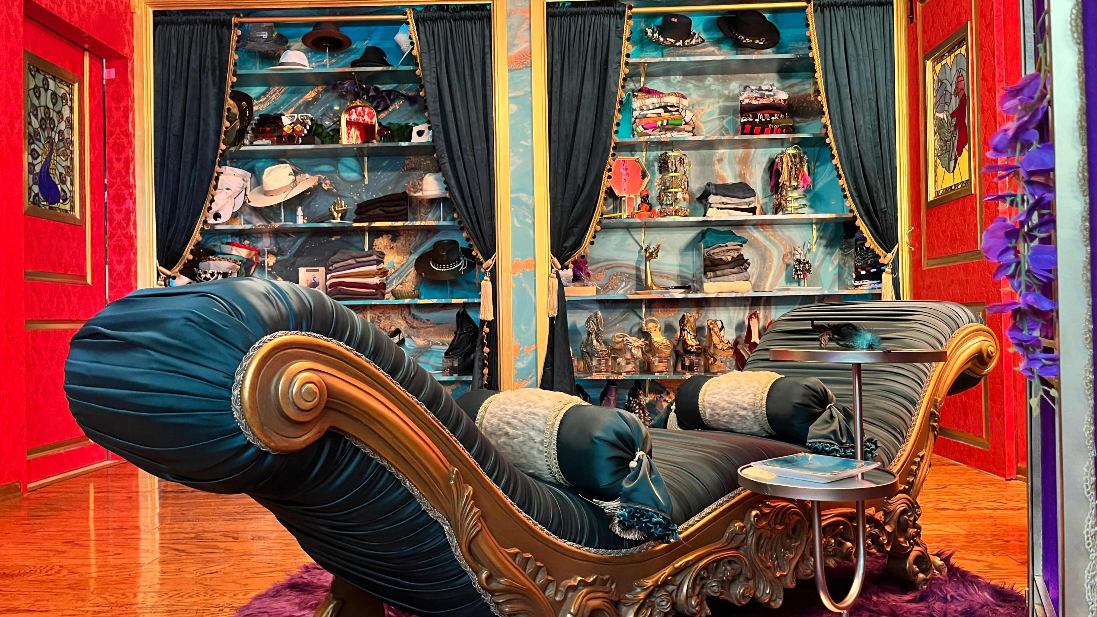 The image shows a colorful room with a lavish sofa and a shelf filled with various decorative items and accessories.