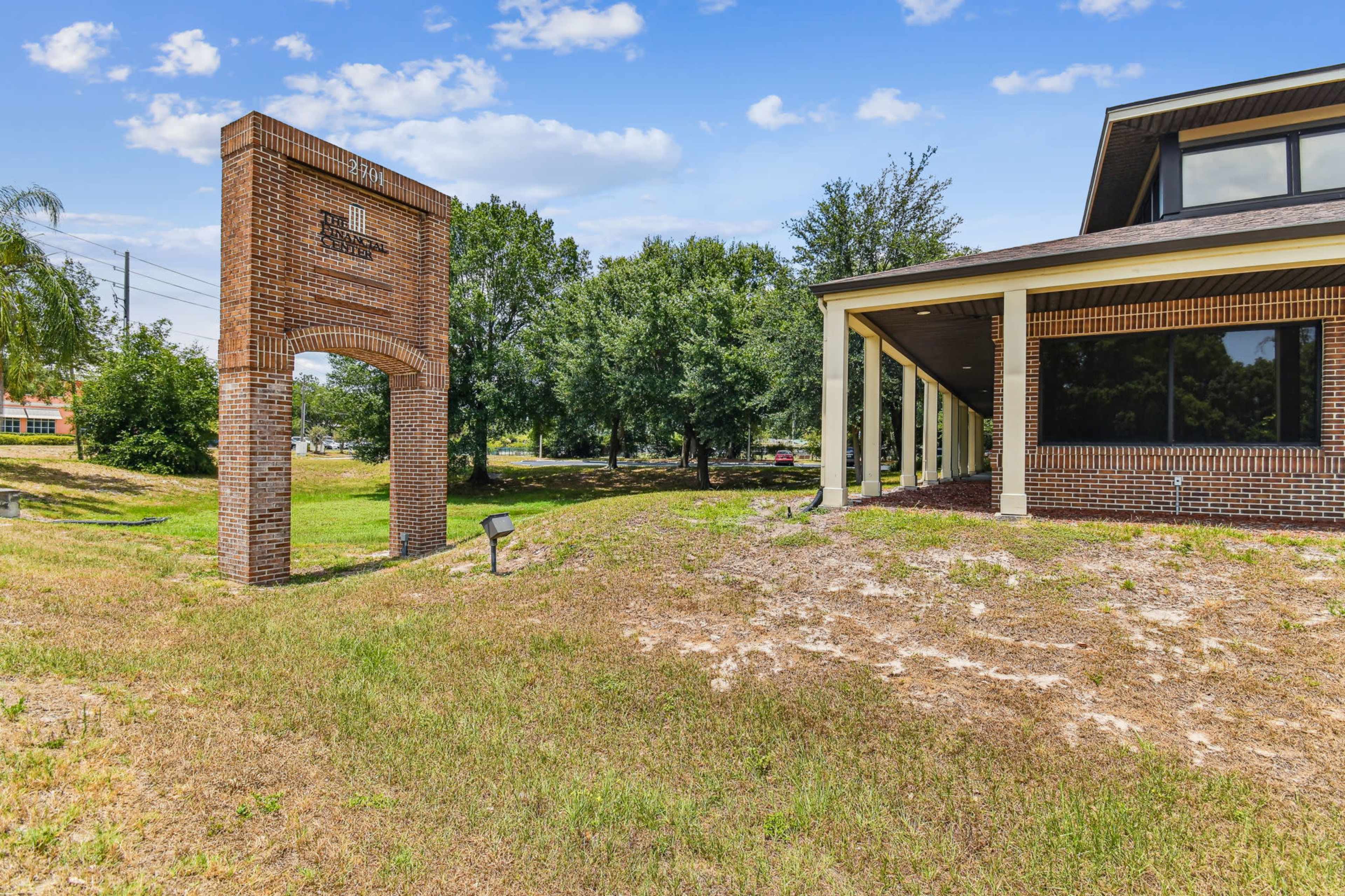 The image shows a brick structure labeled "Library" with a grassy area and trees in the background.