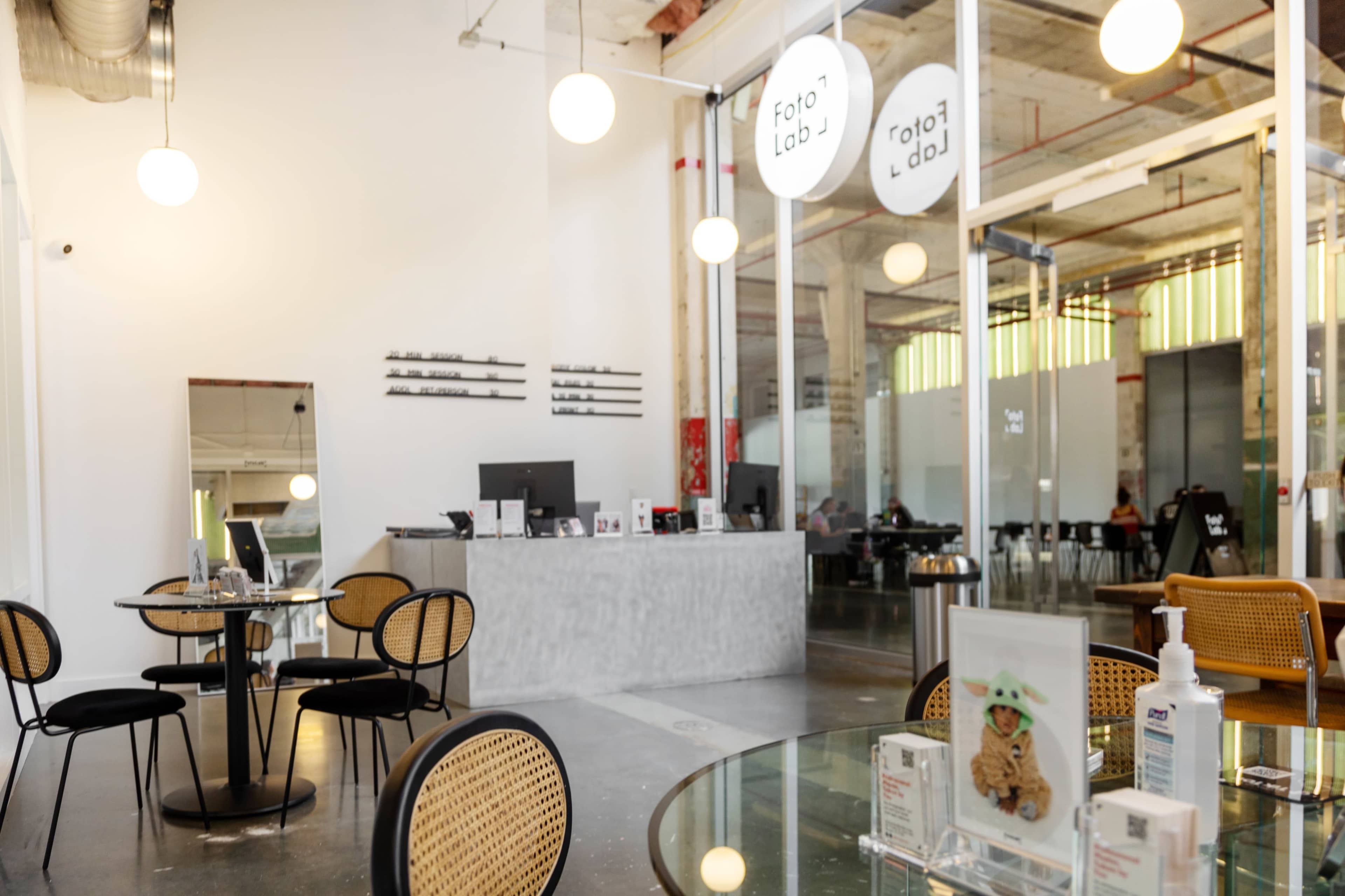 A modern, minimalistic photo lab with a reception area, tables, and artistic decor.