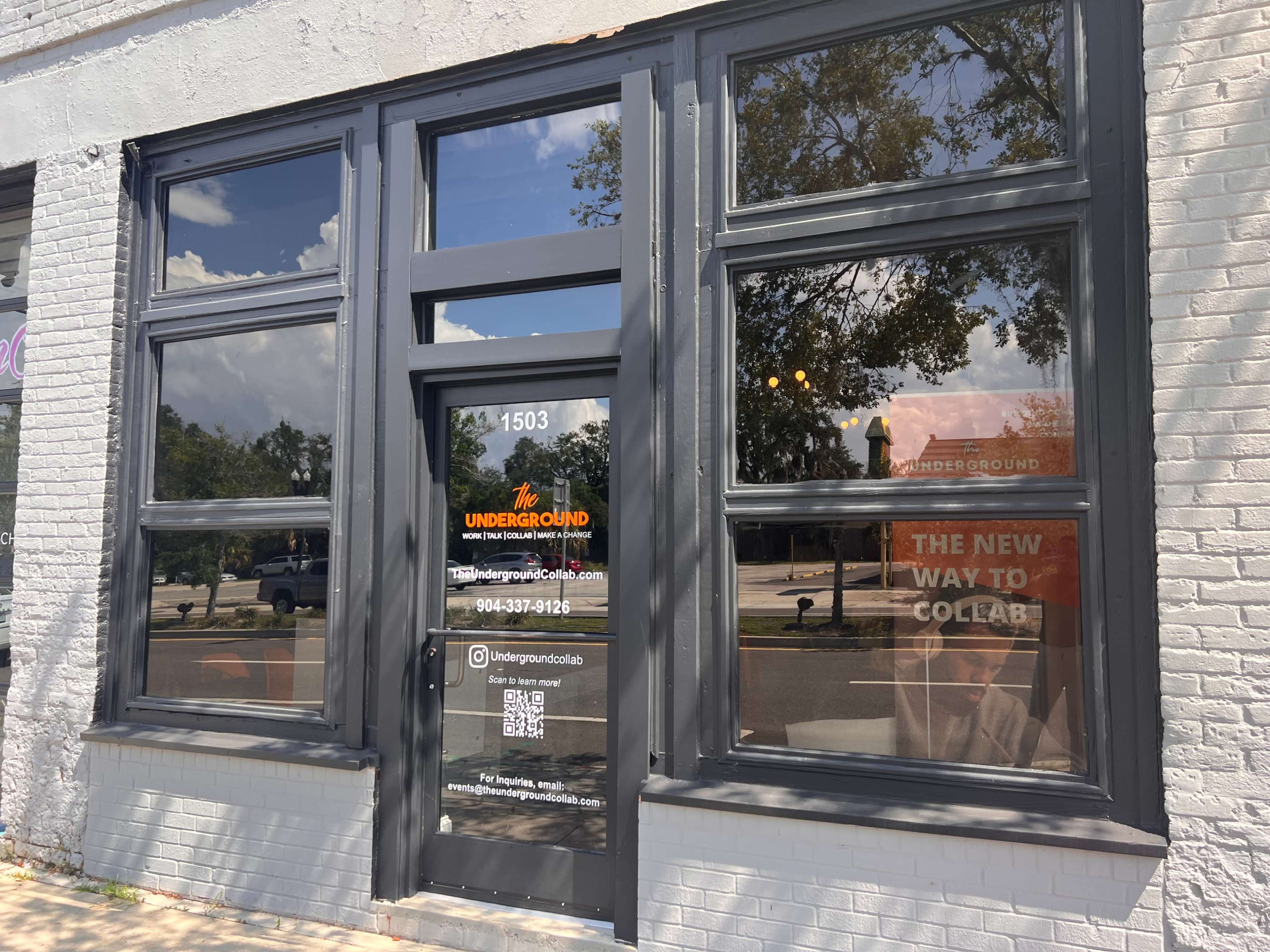 The storefront of "The Underground" with large windows and a sign indicating services available at the location.
