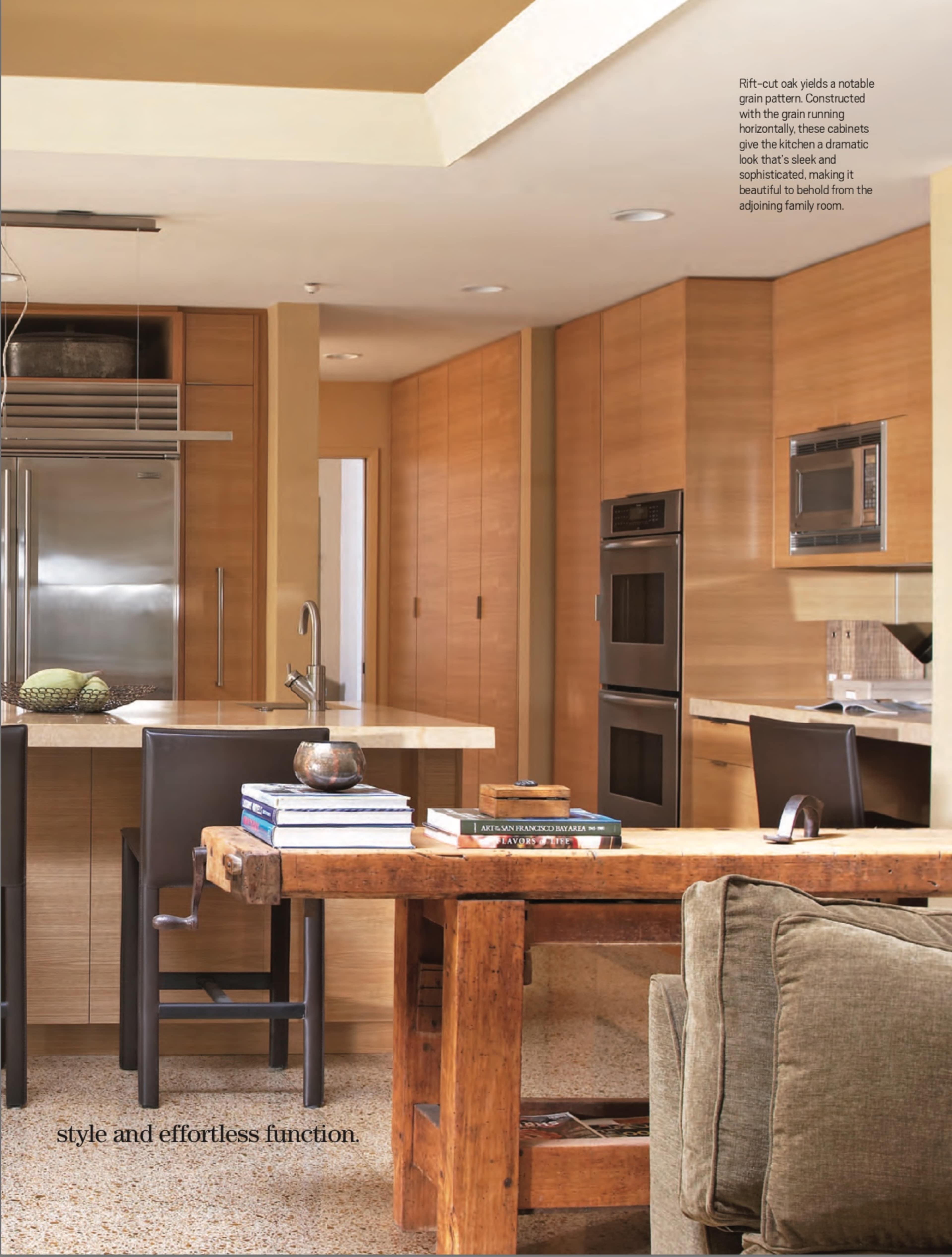 A modern kitchen with wooden cabinetry, stainless steel appliances, and a dining area featuring a large wooden table and chairs.