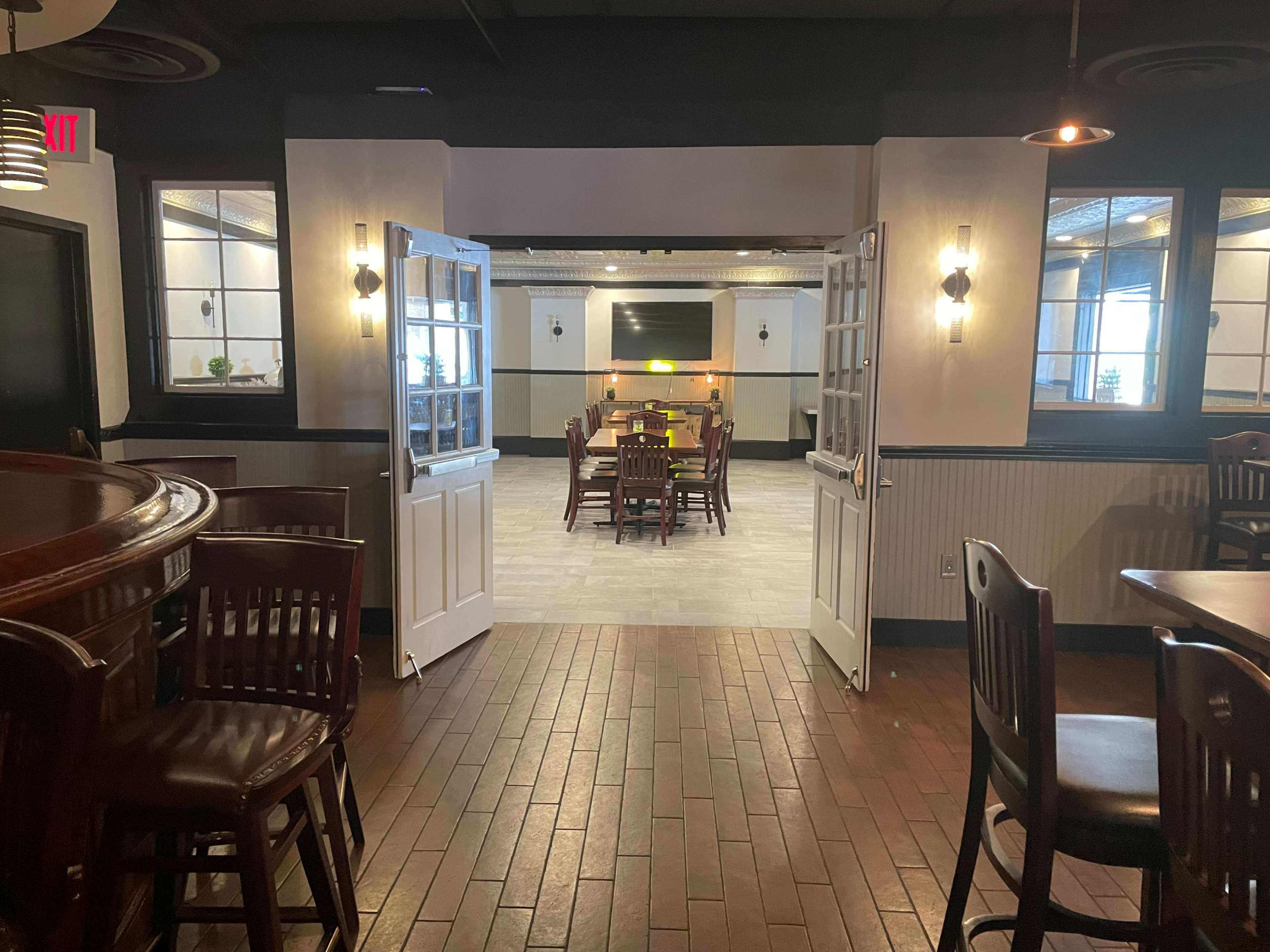 An open doorway leading into a dining area with tables and chairs arranged in a spacious layout.