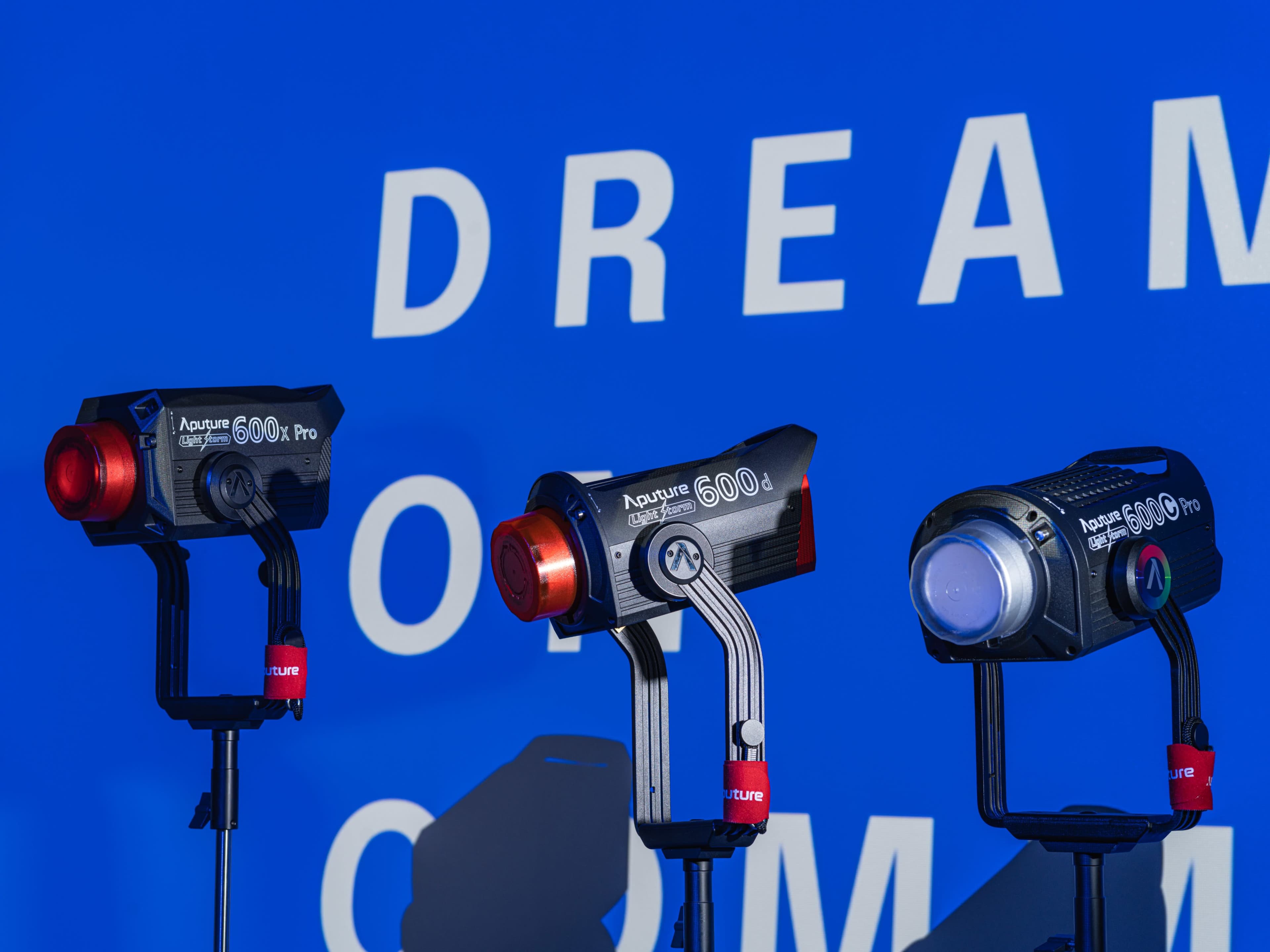 Three Aputure 600x Pro lights are positioned in front of a blue backdrop with the words "DREAM OF" visible.