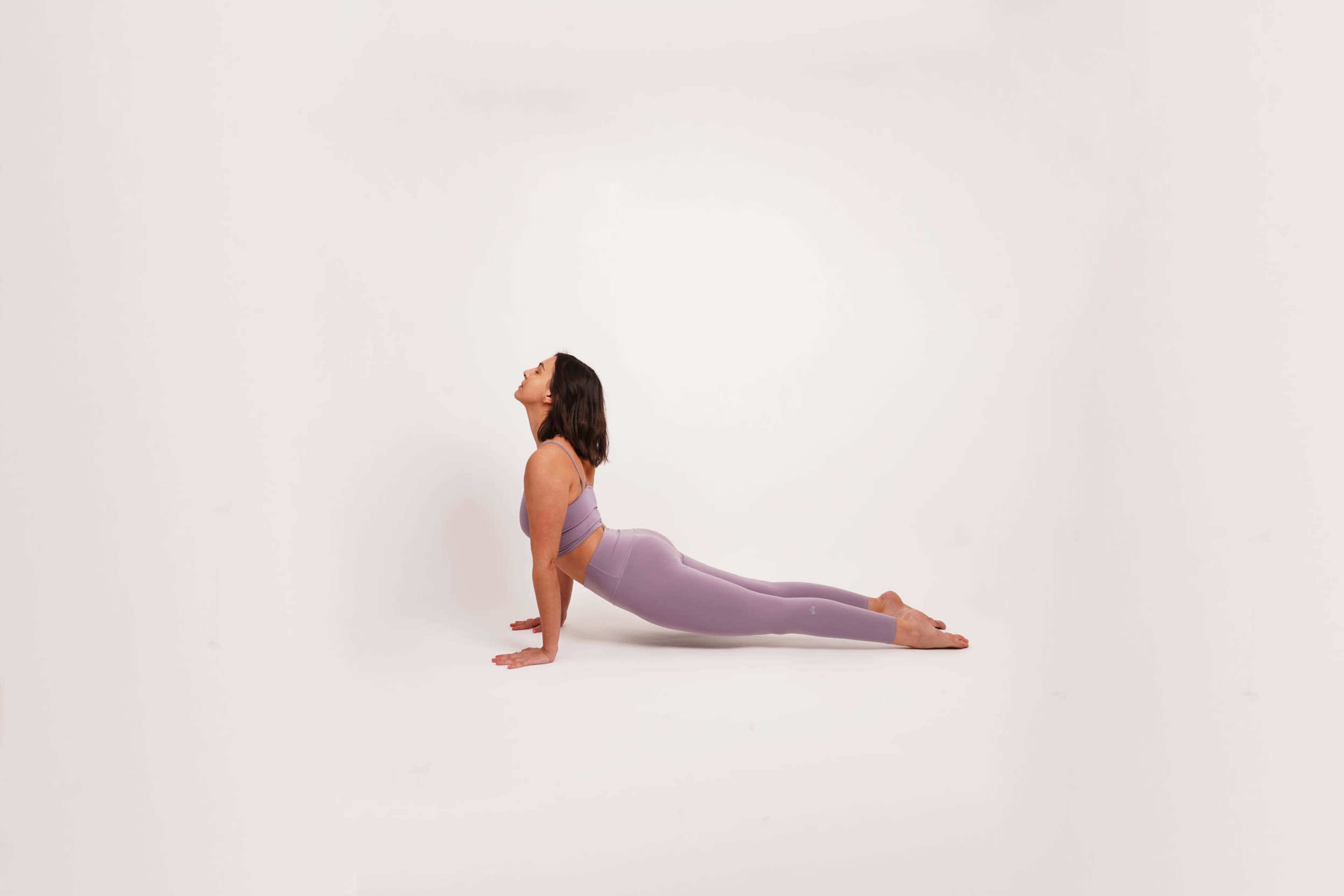 A person is performing a yoga pose on a plain white background.