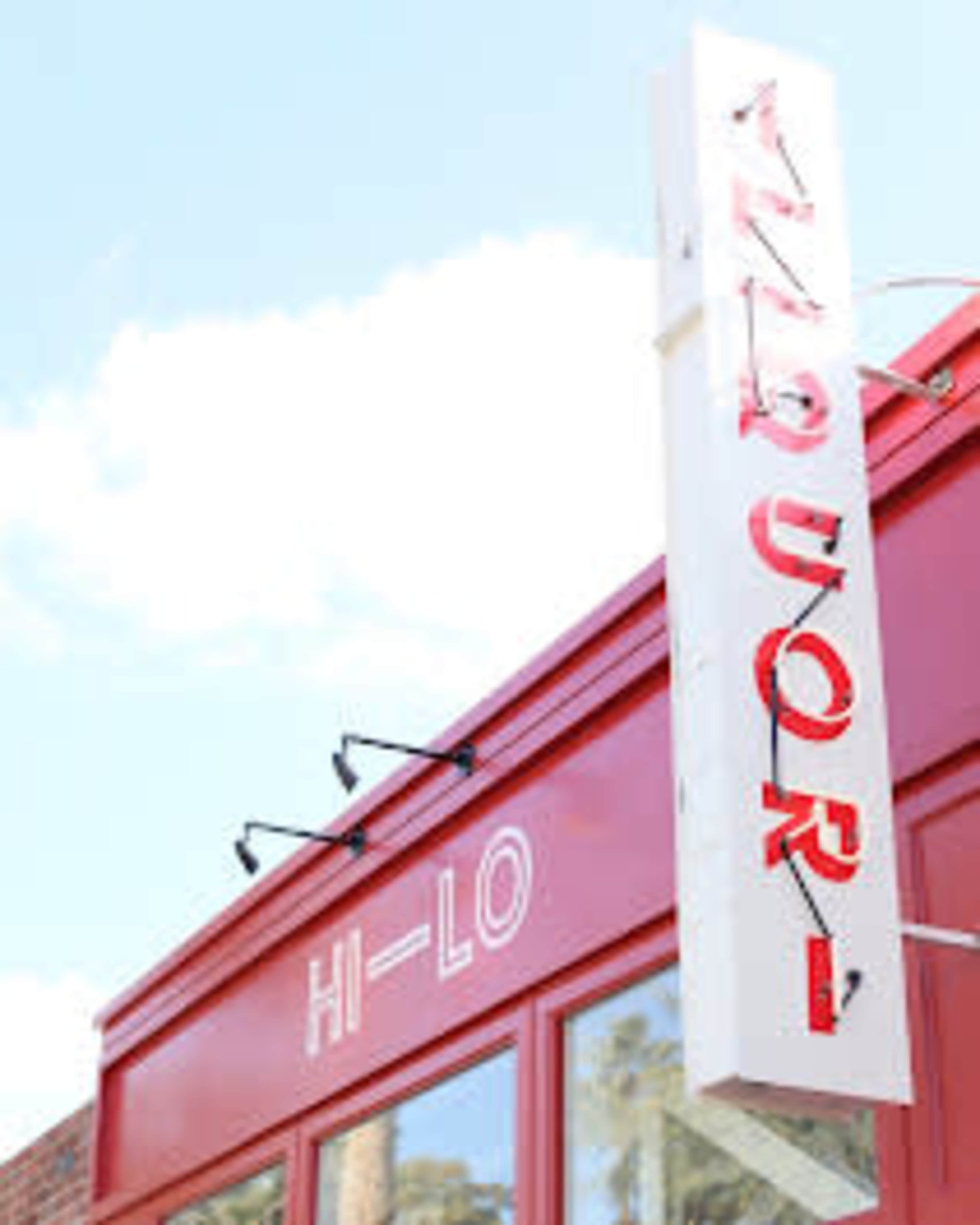 The image shows a red storefront with a sign that reads "LIQUOR" above the entrance.
