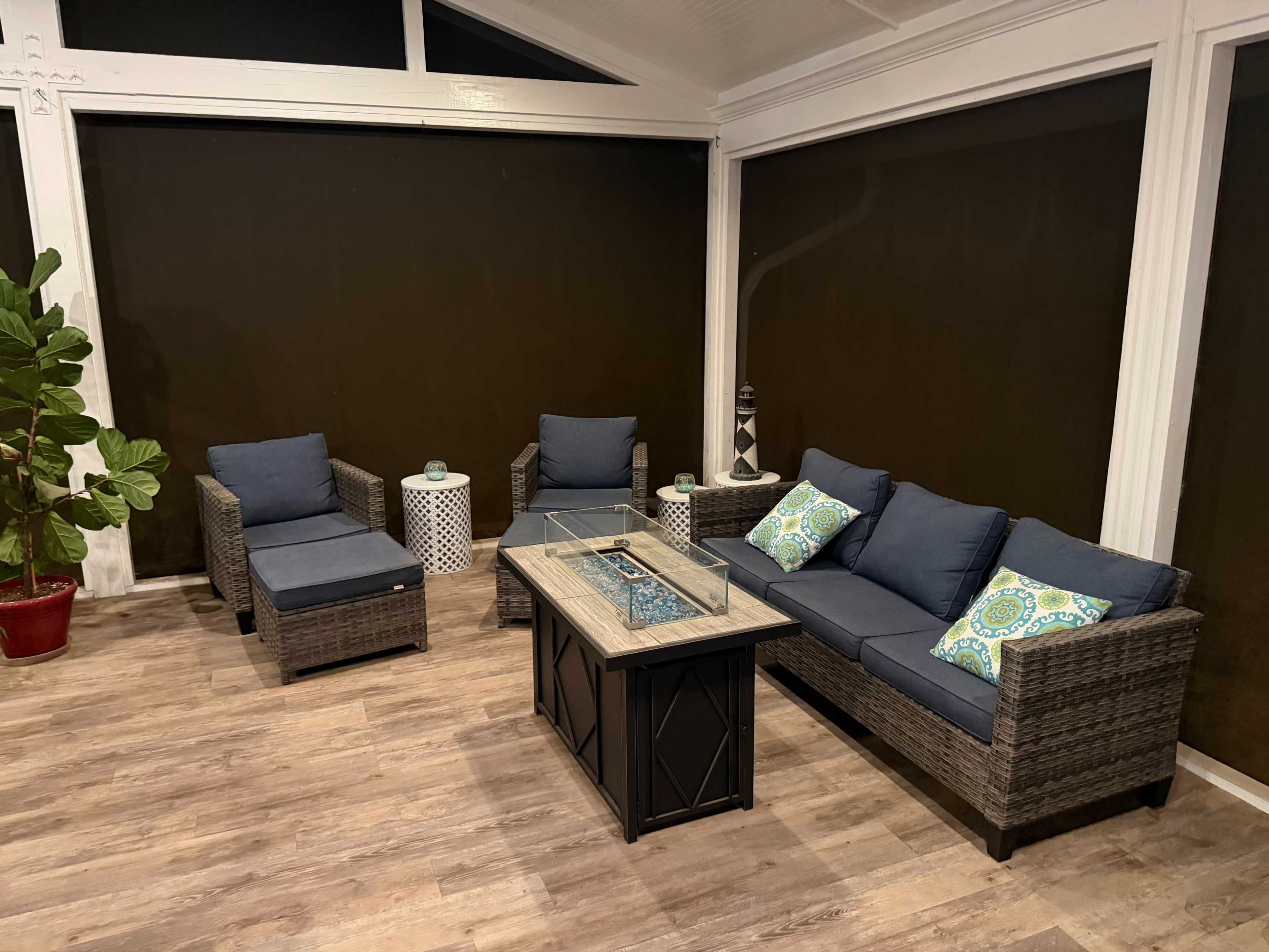 The image shows a cozy sunroom with a seating arrangement including two armchairs and a sofa, accompanied by a rectangular coffee table.