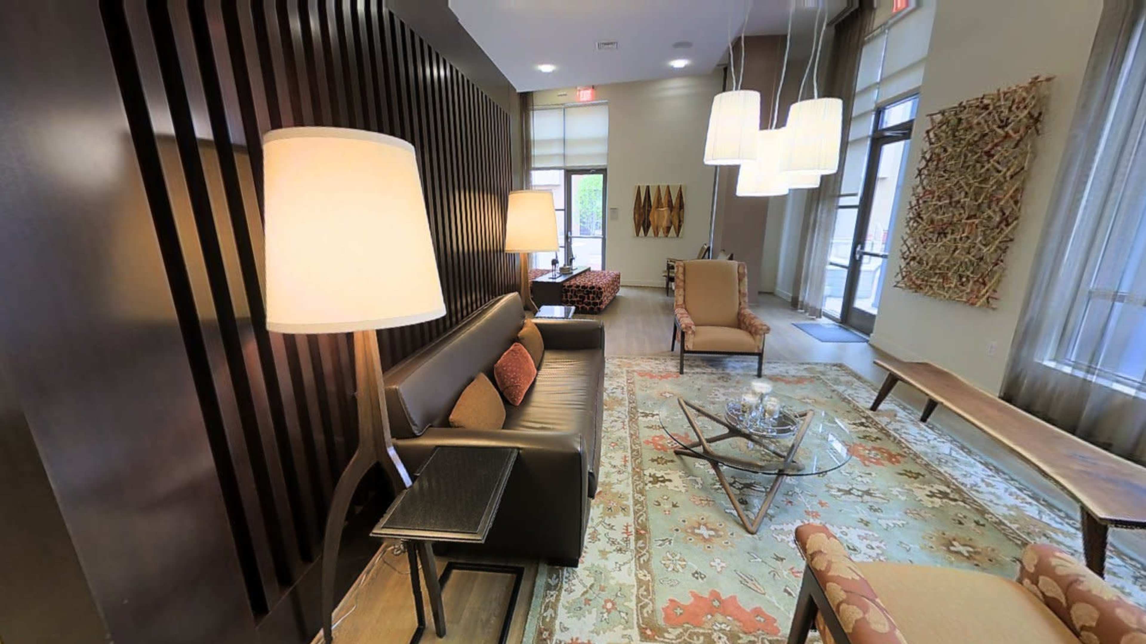 A modern lounge area featuring dark wood accents, comfortable seating, and decorative lighting.