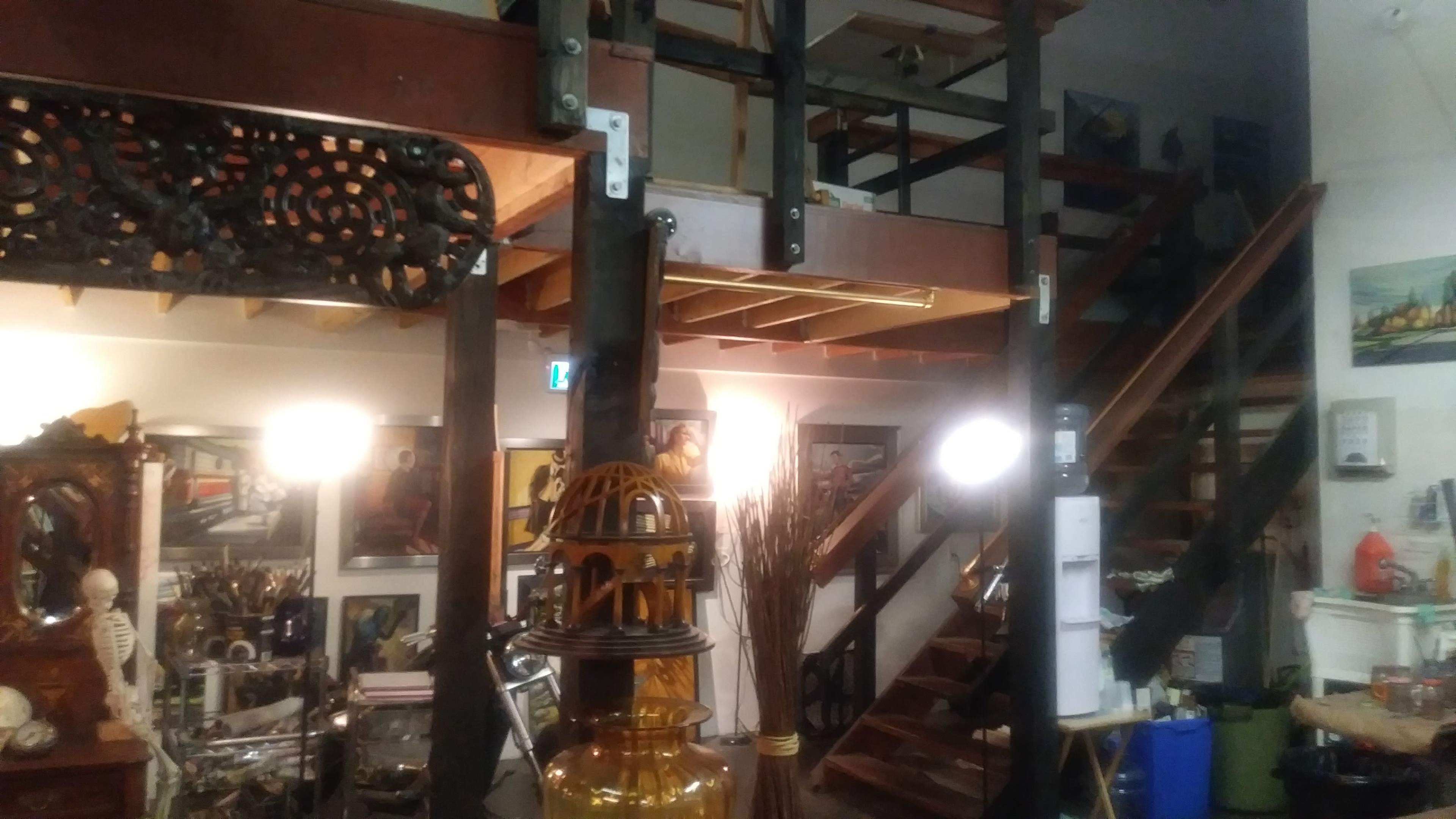 A multi-level room with wooden stairs and a variety of decorative items, including artwork and furniture.