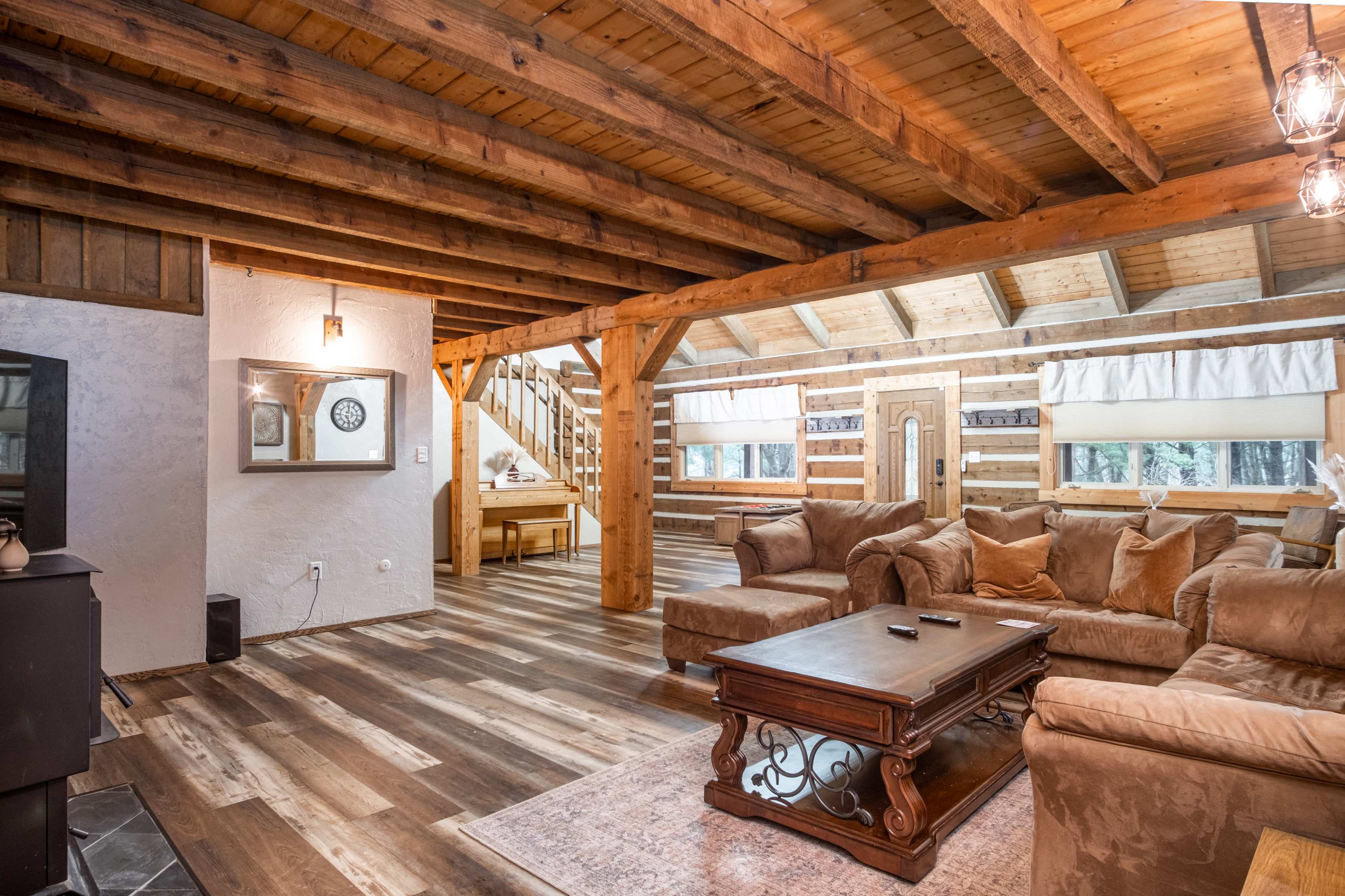 A cozy wooden interior of a lodge-style living area with exposed beams, a comfortable sofa, and a coffee table.