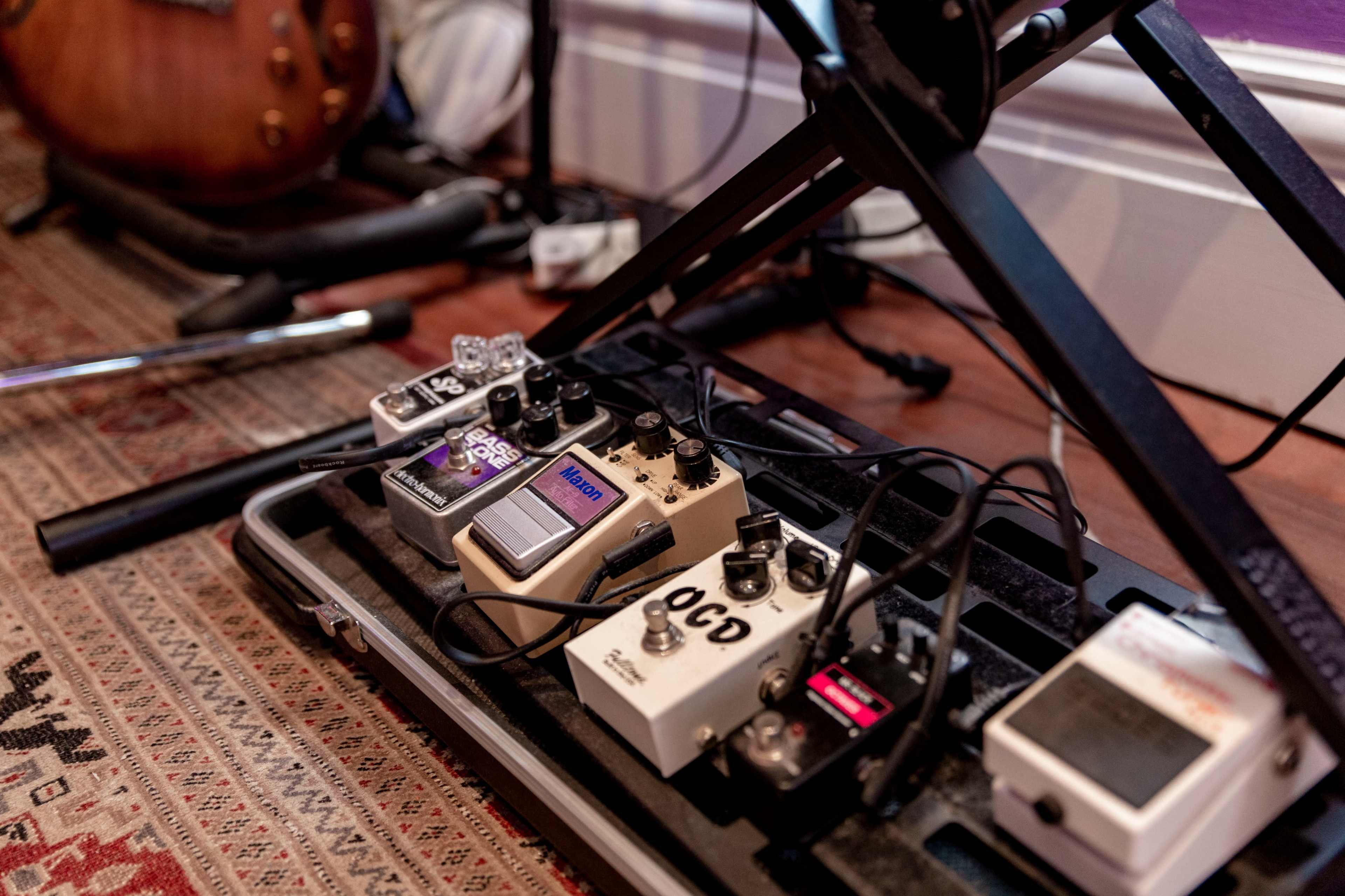 A close-up view of a collection of guitar effects pedals arranged on a pedalboard.