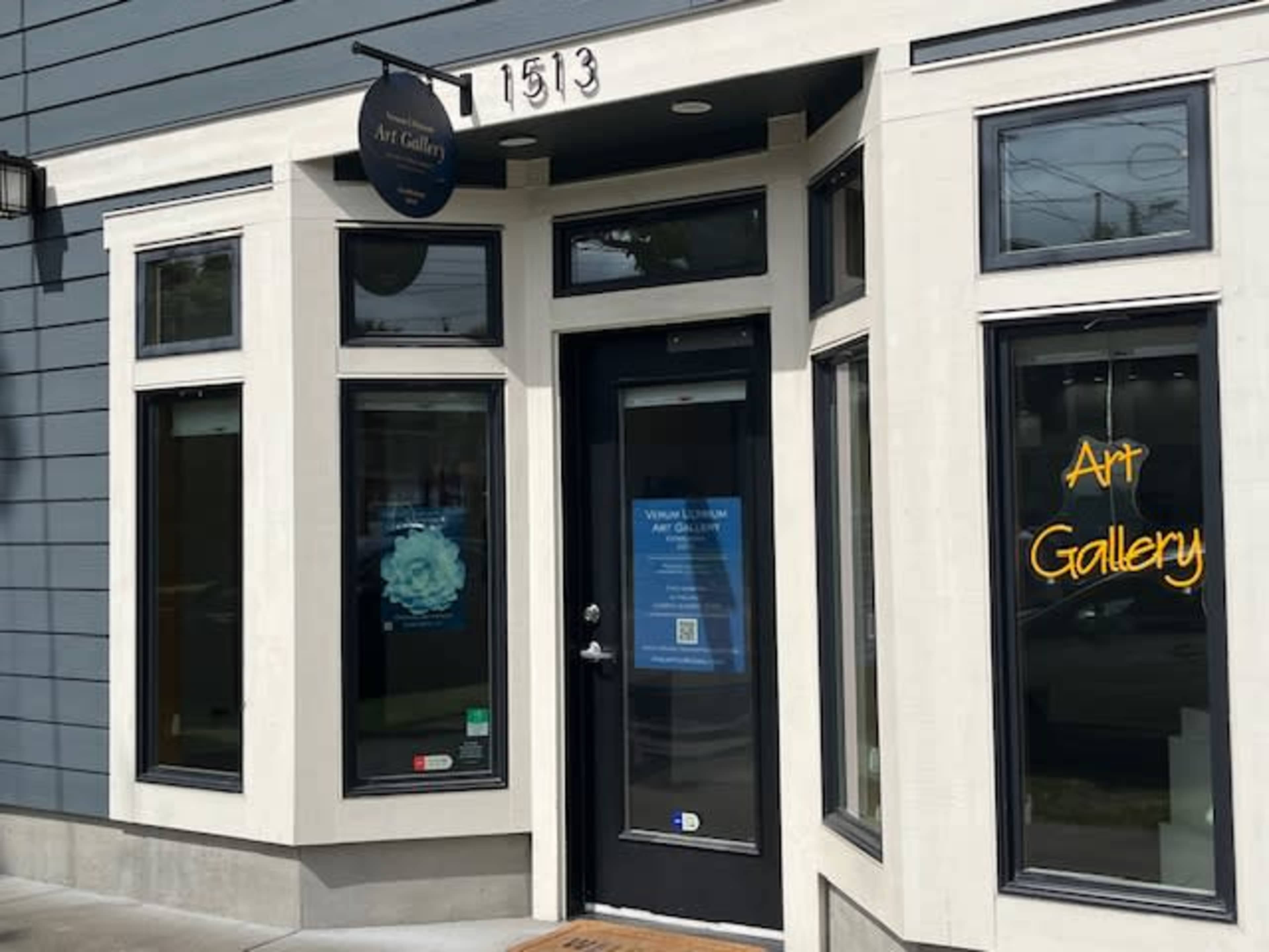 The image shows the entrance of an art gallery, featuring large windows and a sign above the door displaying "Art Gallery."