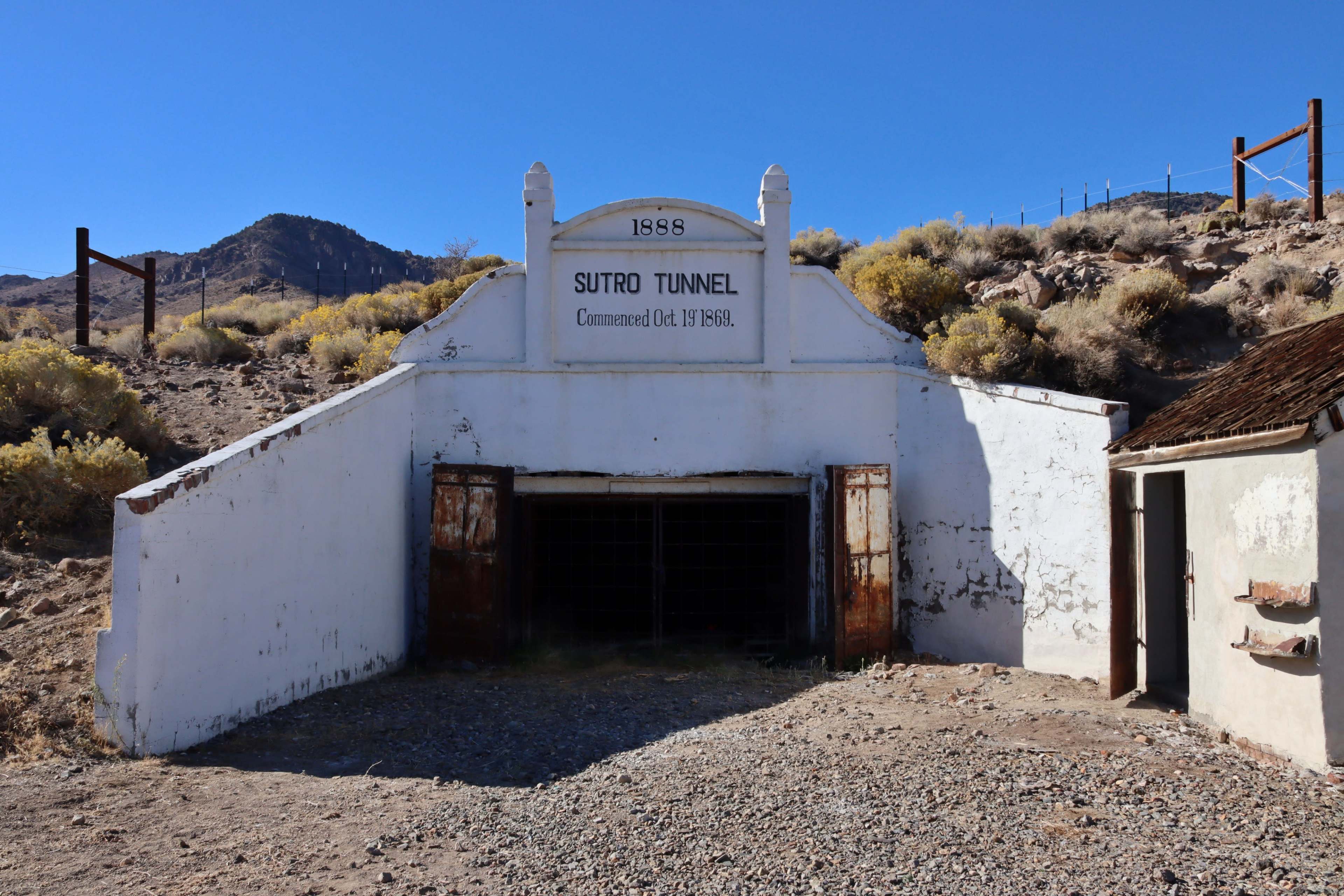 The entrance to the Sutro Tunnel, featuring a white archway with the inscription "1898" and "Commenced Oct 14, 1891."