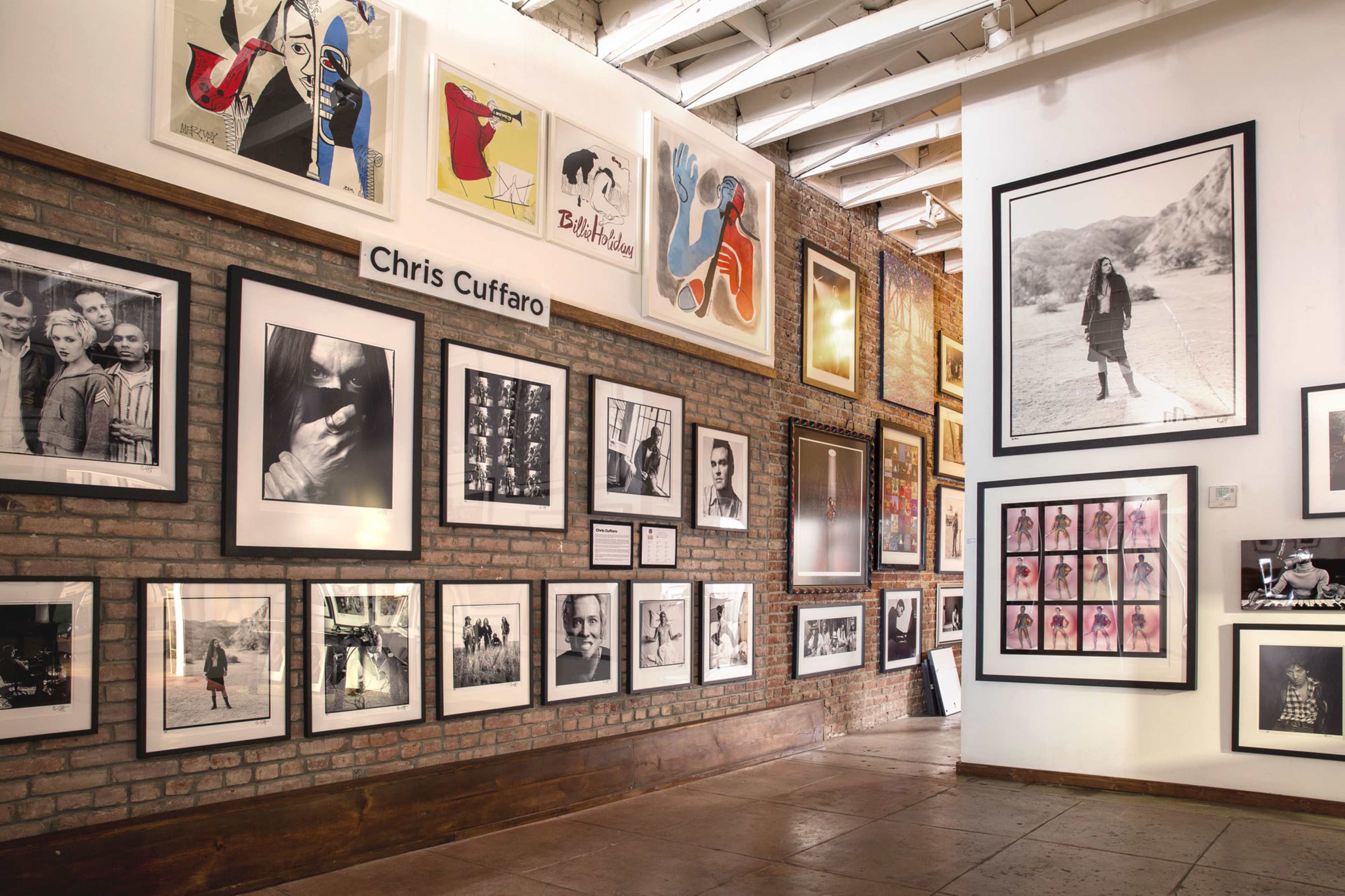 A gallery wall showcasing various framed photographs and artwork arranged in a modern art setting.