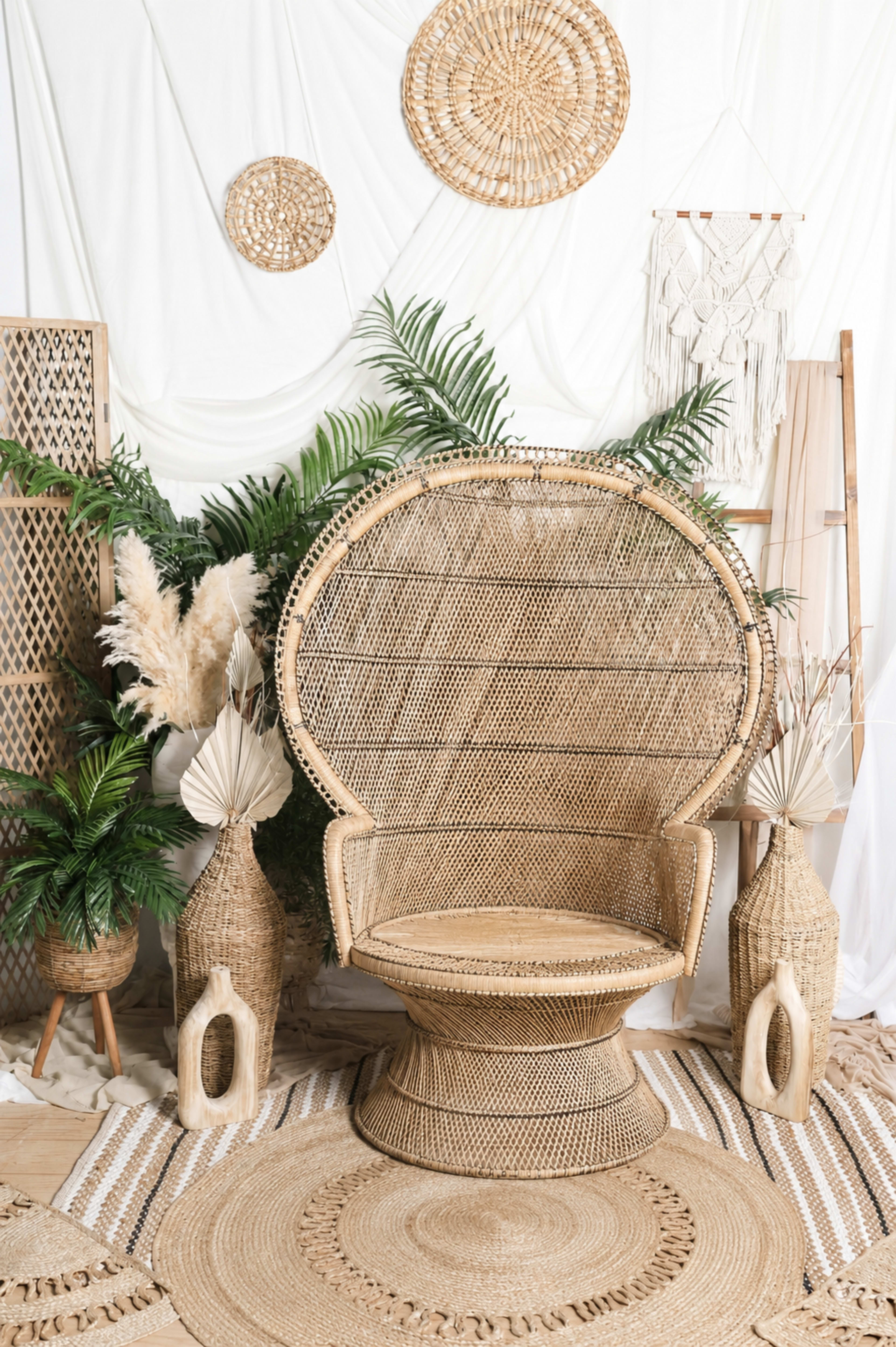 The image features a bohemian-style seating area with a large woven chair, decorative plants, and various woven wall hangings.