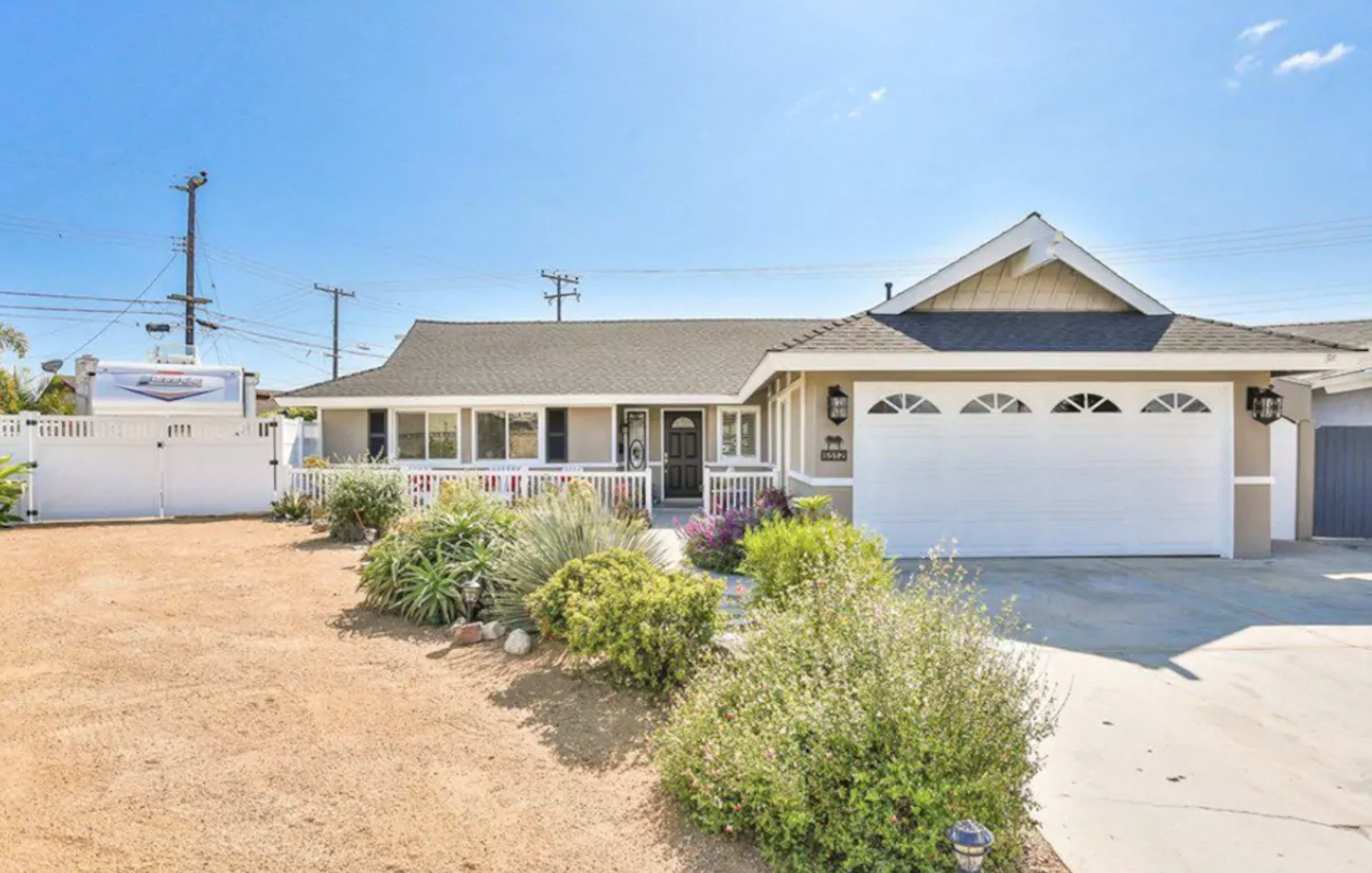 A single-story house with a landscaped yard, a front porch, and a two-car garage in a suburban setting.