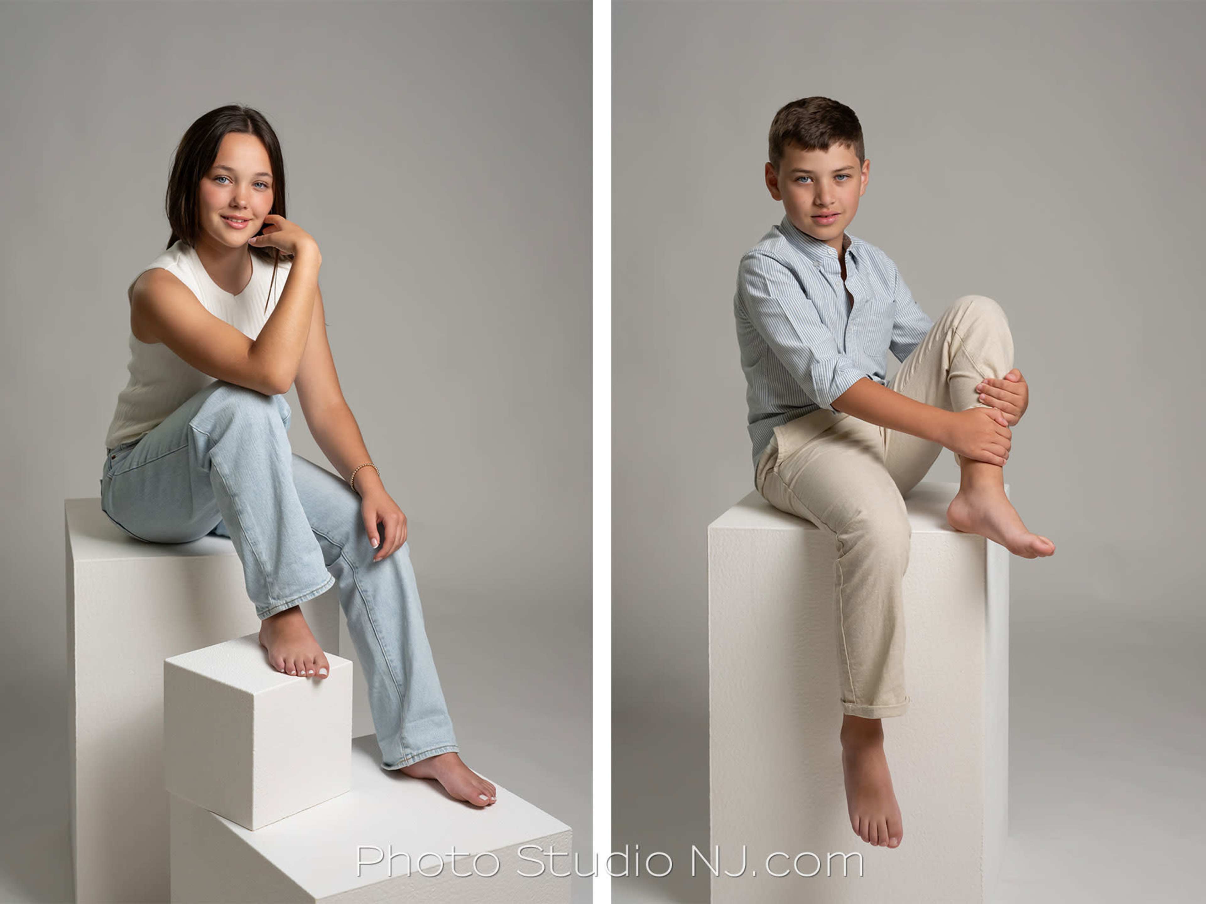 Two children are posed on separate white cubes against a neutral background, one girl sitting with her legs crossed and a boy seated with his arms resting on his knees.