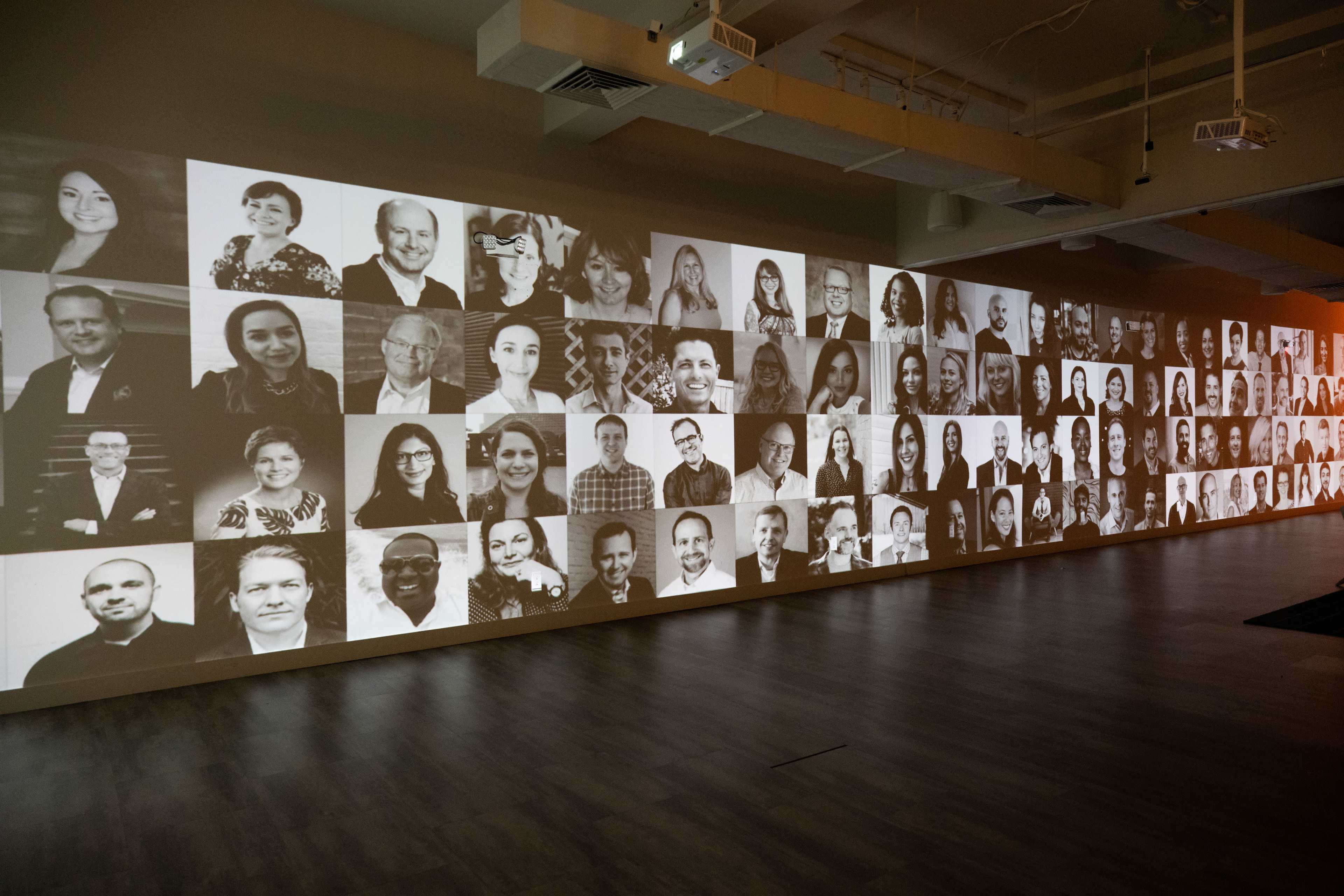 A large wall displaying a collage of black and white portraits of various individuals.