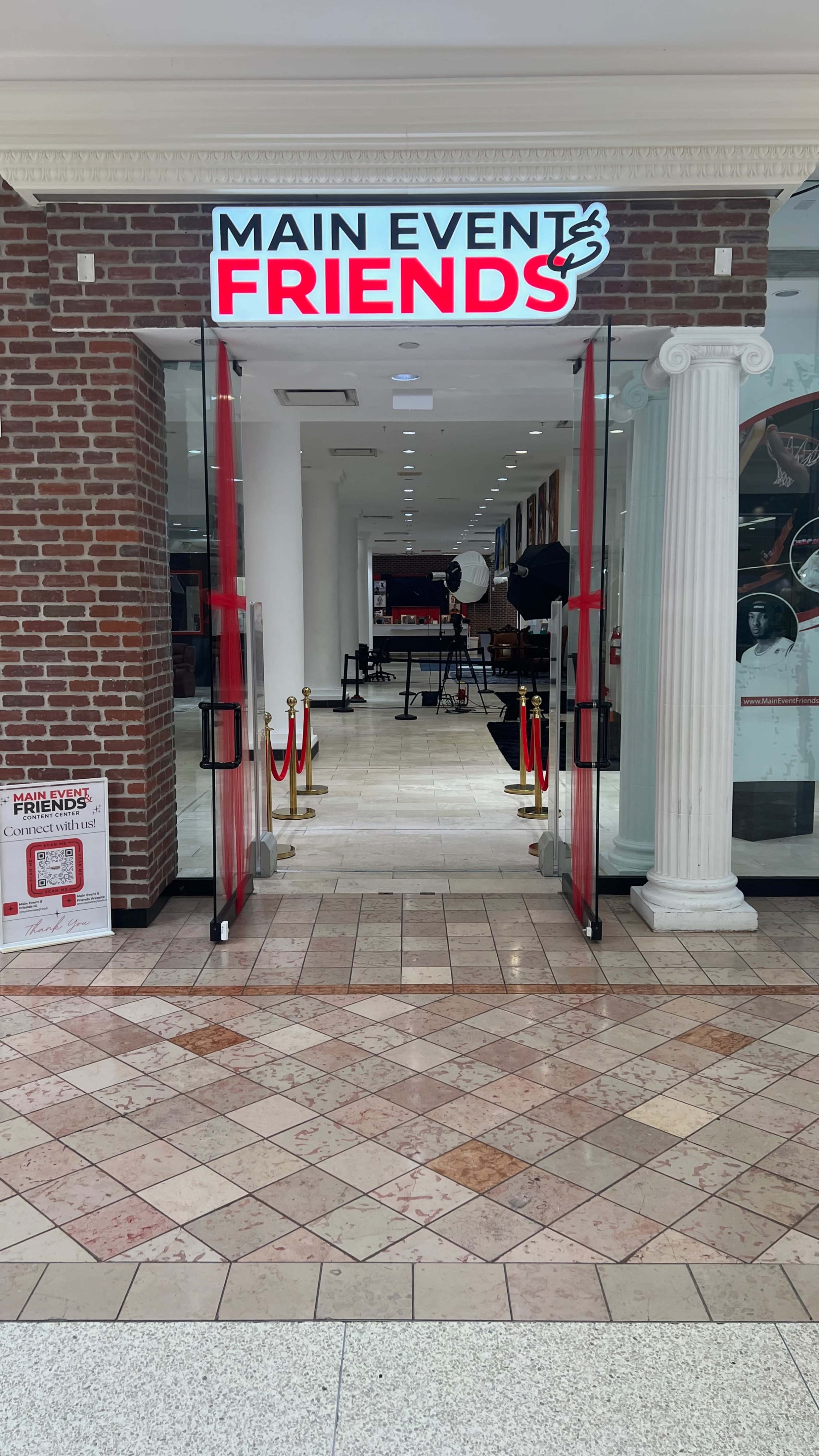 The entrance of a venue called "Main Event Friends" is visible, featuring a red and white sign and a hallway leading into the space.