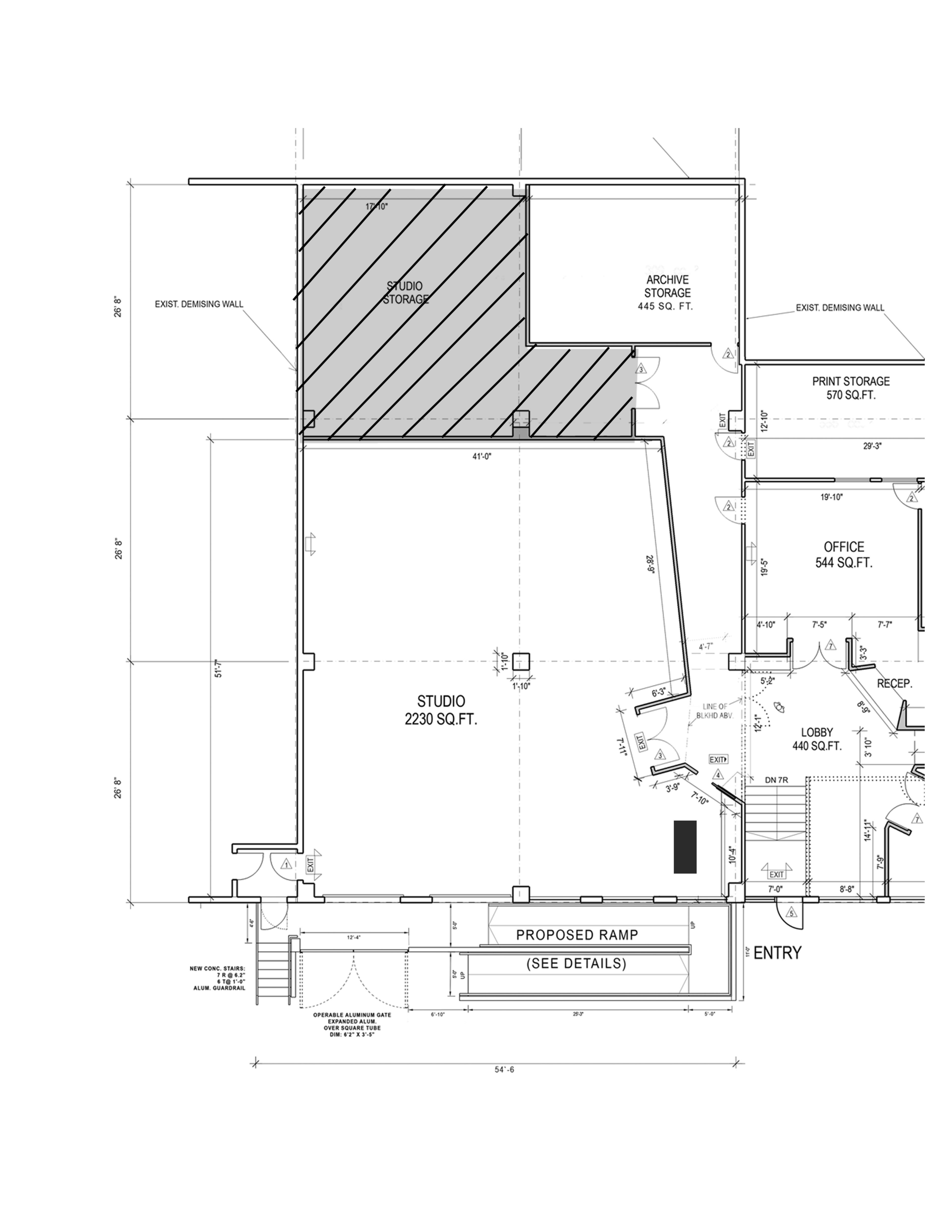 The image is a floor plan layout showing various areas, including a studio, office, lobby, and proposed ramp, with labeled dimensions and existing walls.