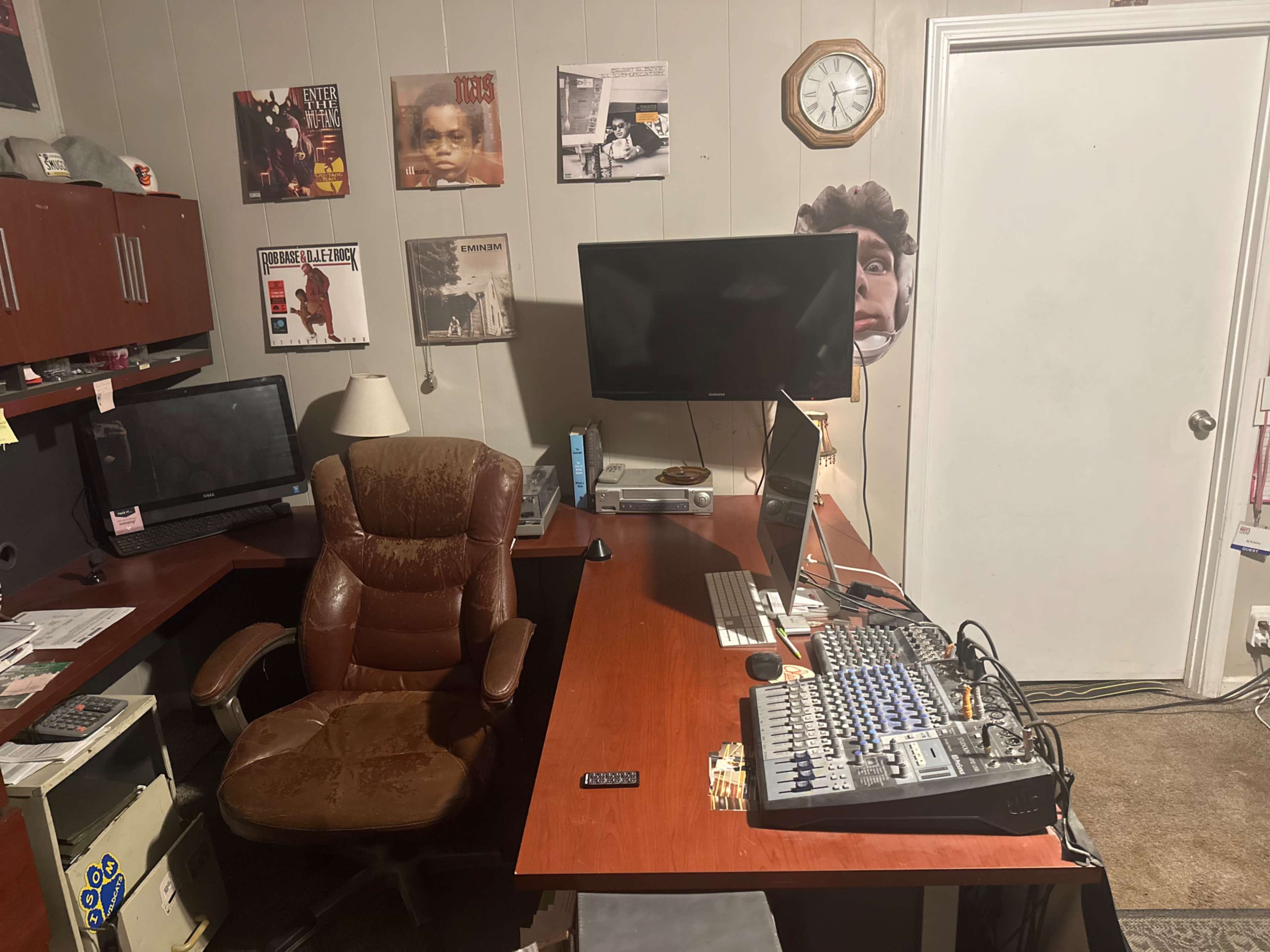 A home office is shown with two computer monitors, a sound mixing console, a leather office chair, and music-themed wall decorations.