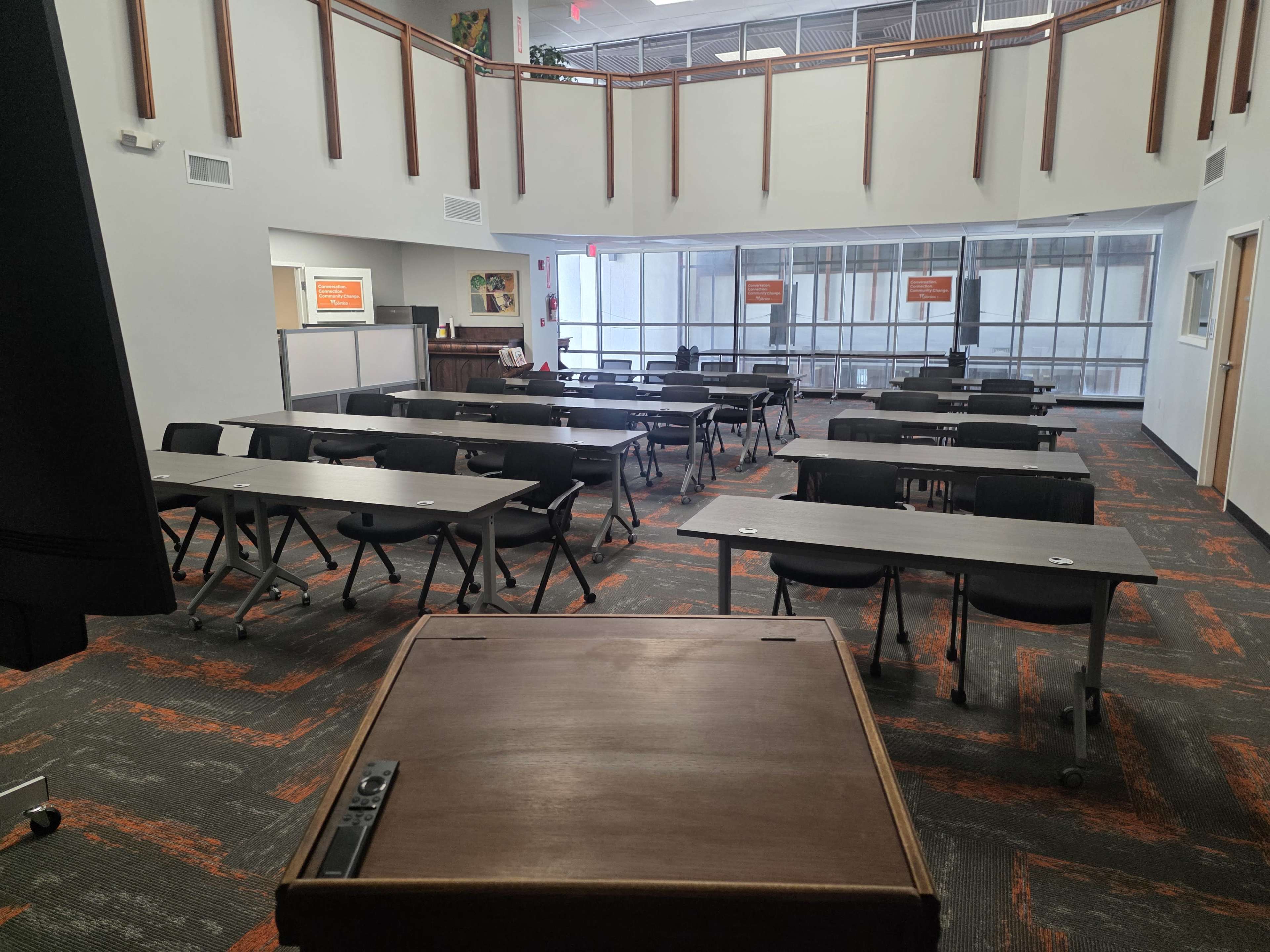 A classroom with multiple rows of tables and chairs arranged in a spacious layout.