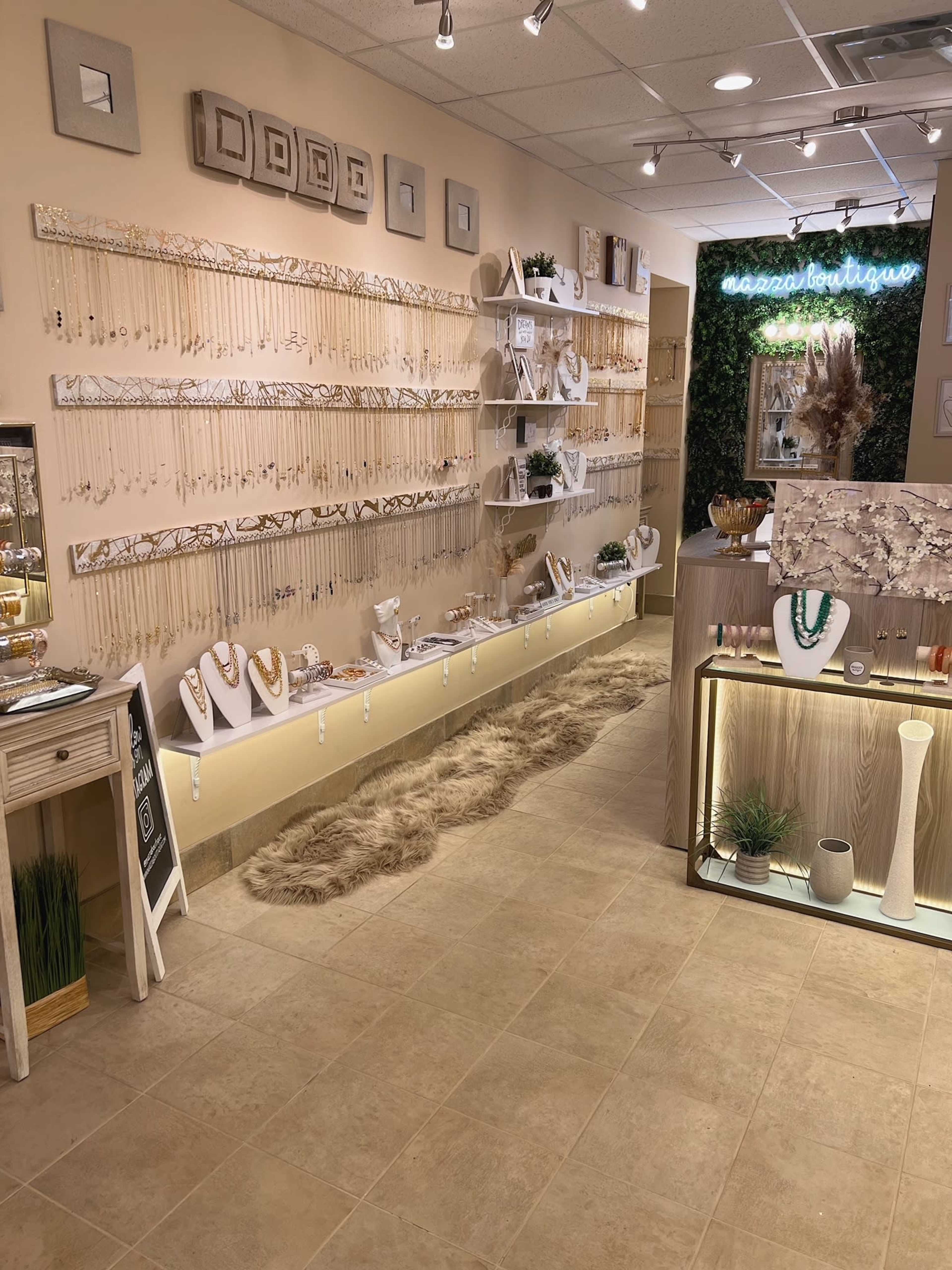 A jewelry store interior featuring well-organized displays of necklaces and accessories on shelves along a light-colored wall.