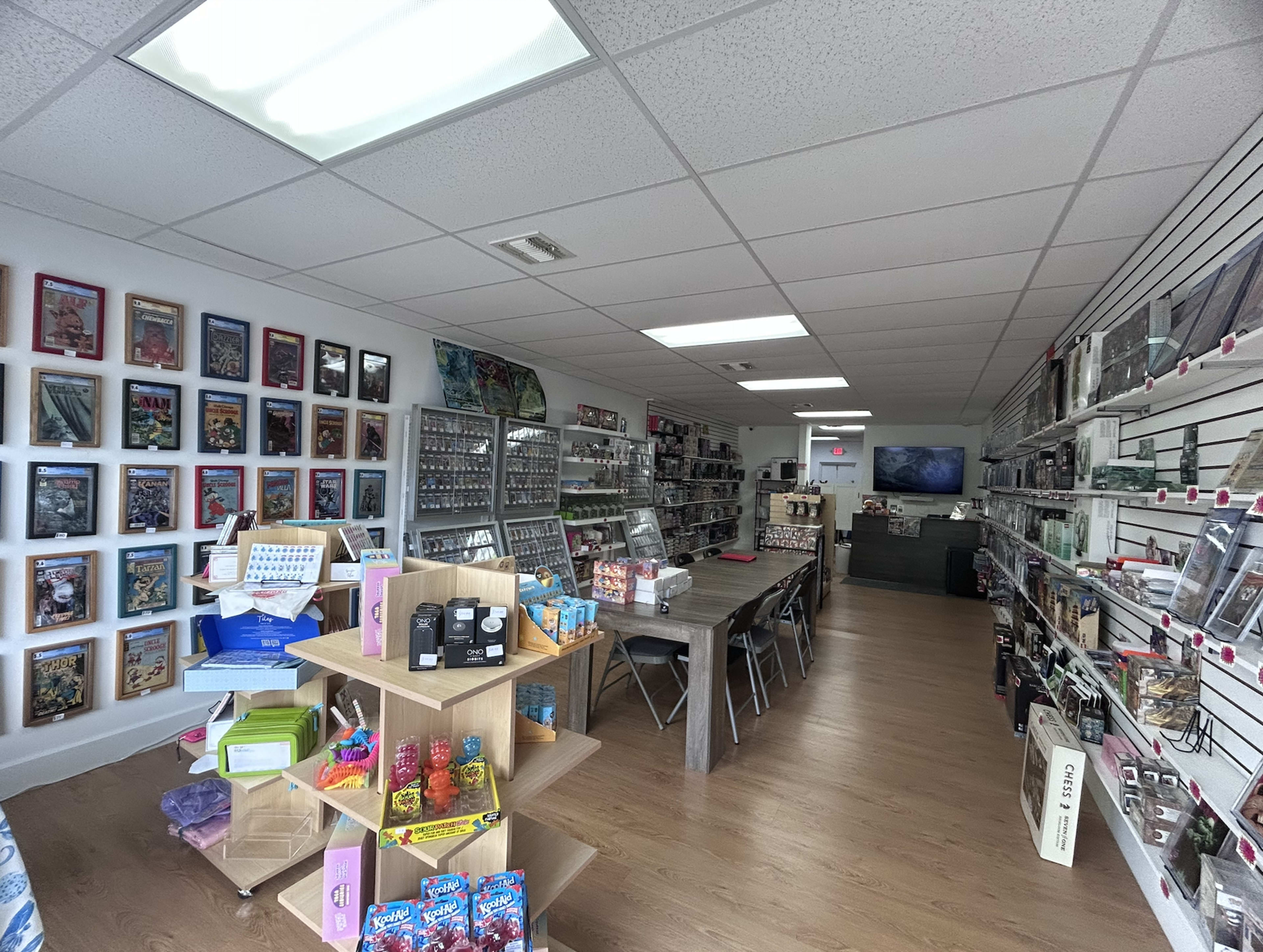 The image shows the interior of a retail store featuring shelves lined with various collectible items and merchandise, along with displays of candies and games.