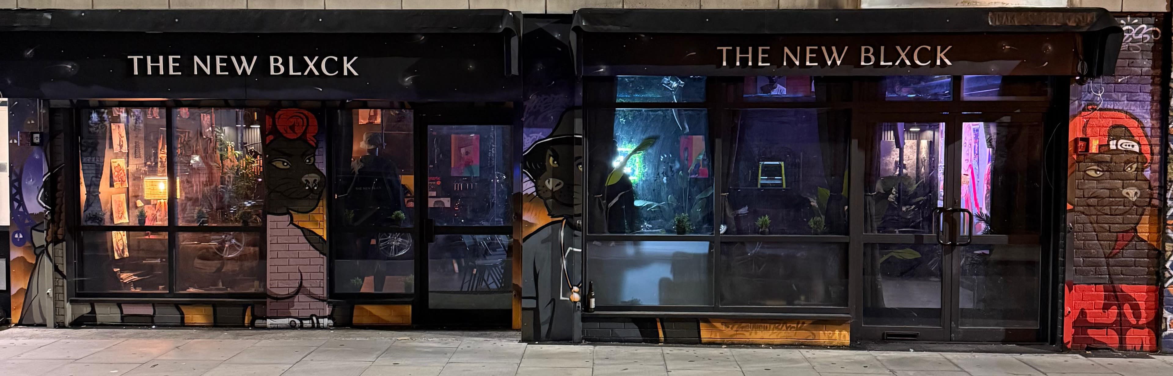 The image shows the storefront of a venue called "The New Blxck," featuring large windows with artistic murals on either side.