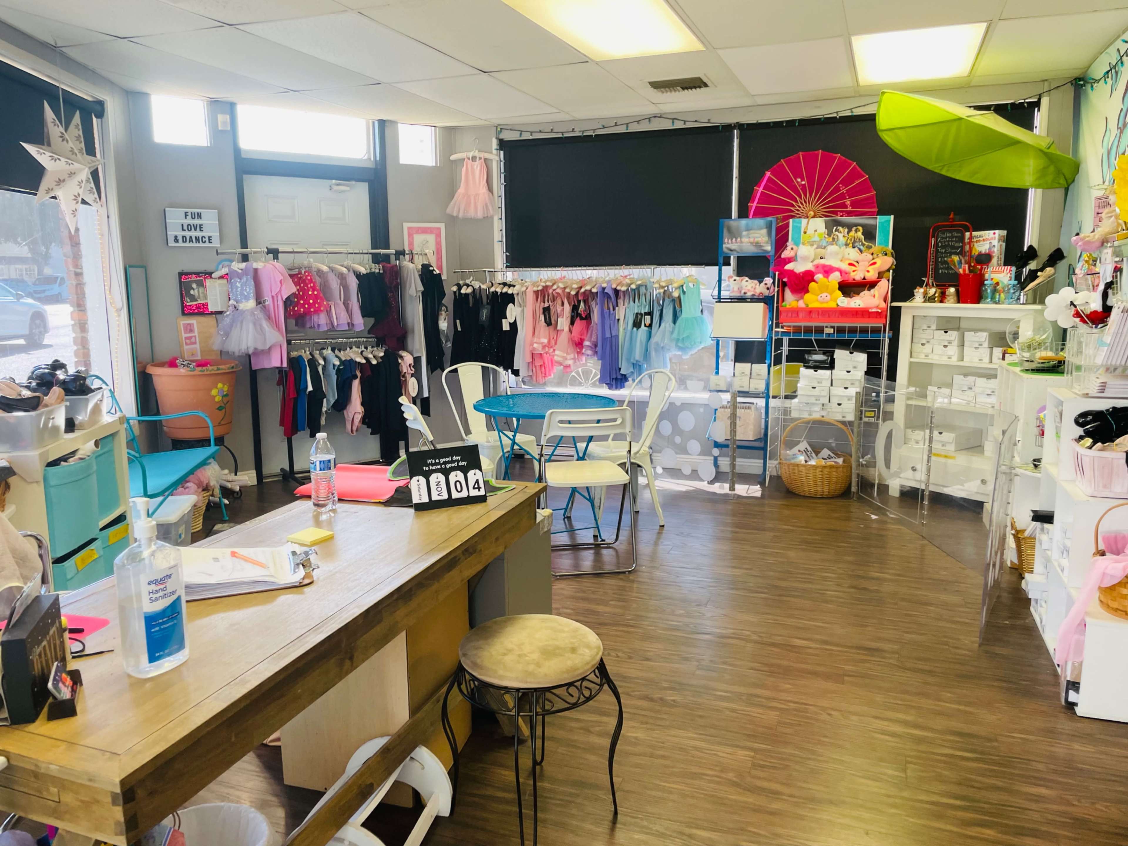 A brightly lit retail space with children's clothing displays, a check-out counter, and shelves filled with toys and accessories.