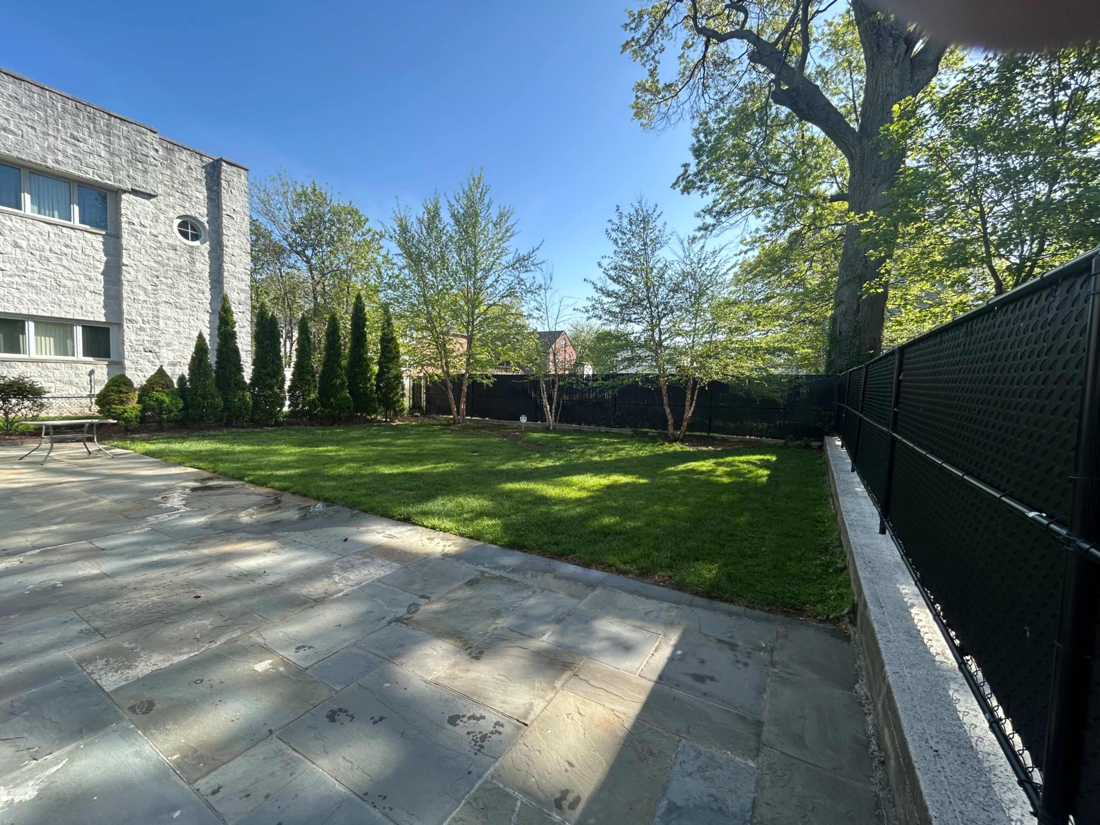 Charming Backyard Oasis with Lush Lawn & Stone Patio Image in South Side, Mount Vernon, NY