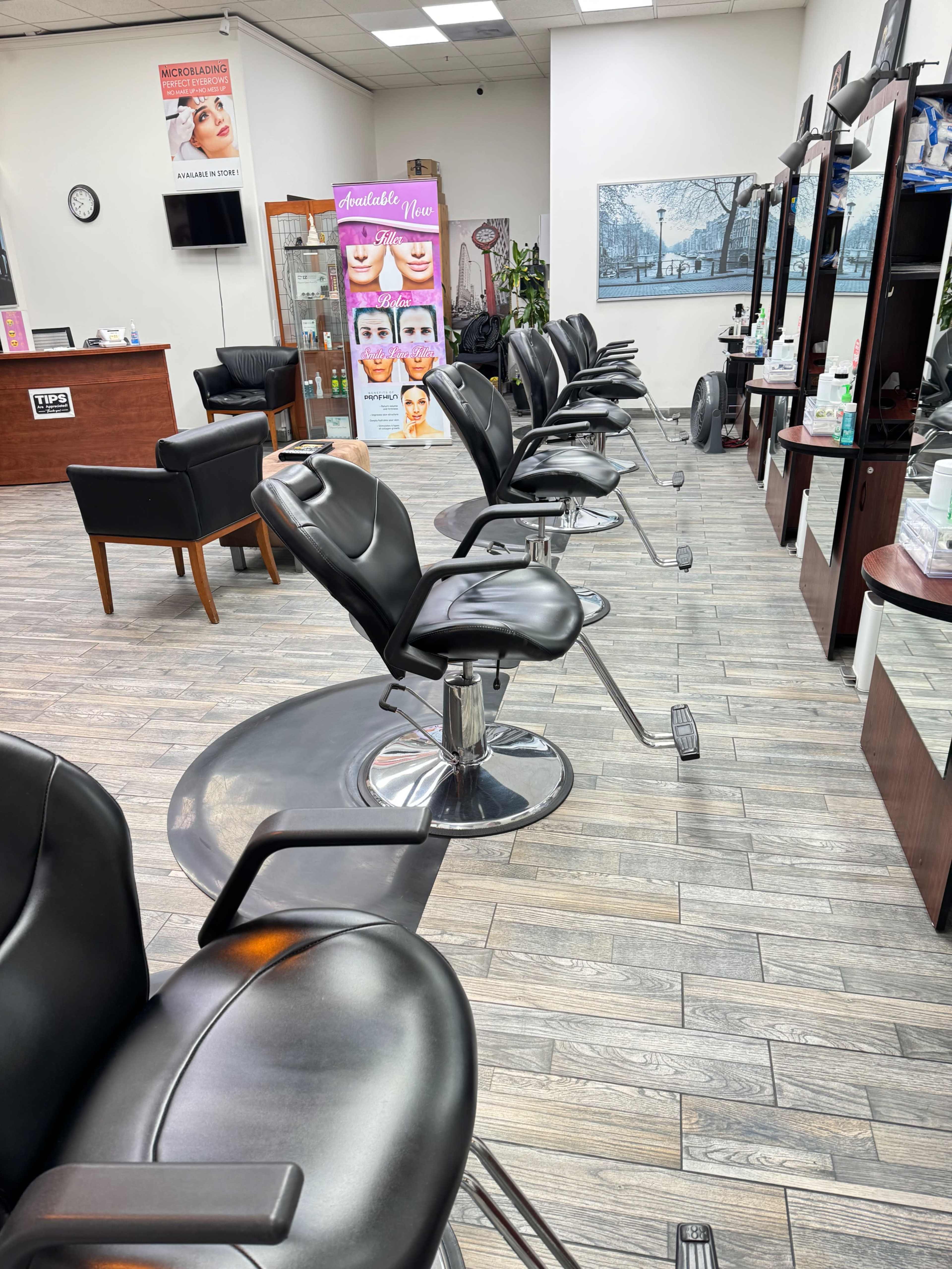 The image shows a row of salon chairs positioned in a well-lit beauty salon, with mirrors and a reception area in the background.