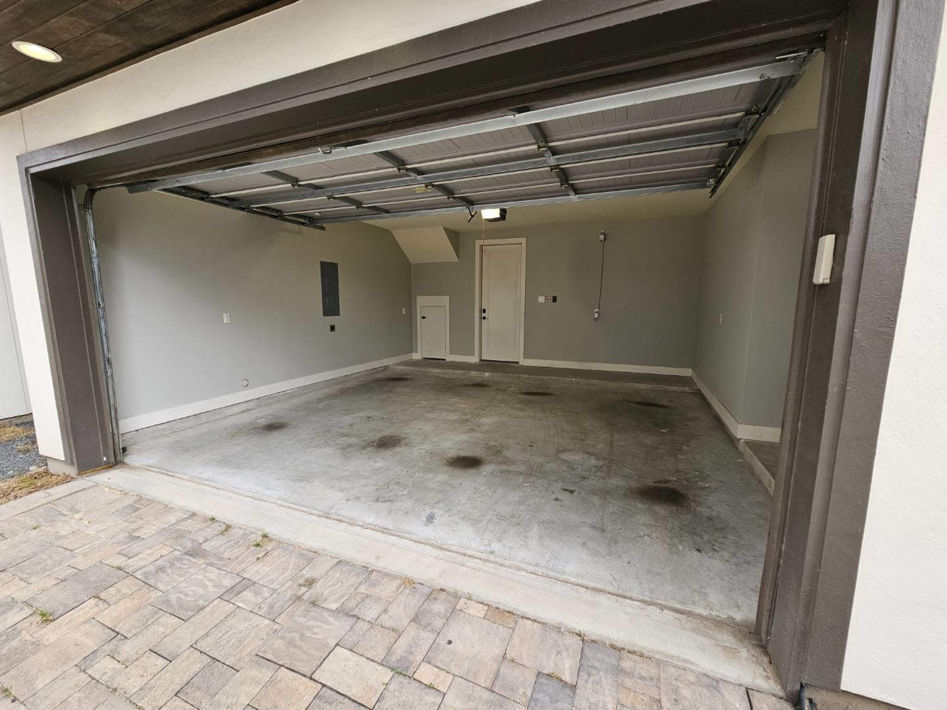 An empty garage with a gray interior and a concrete floor.