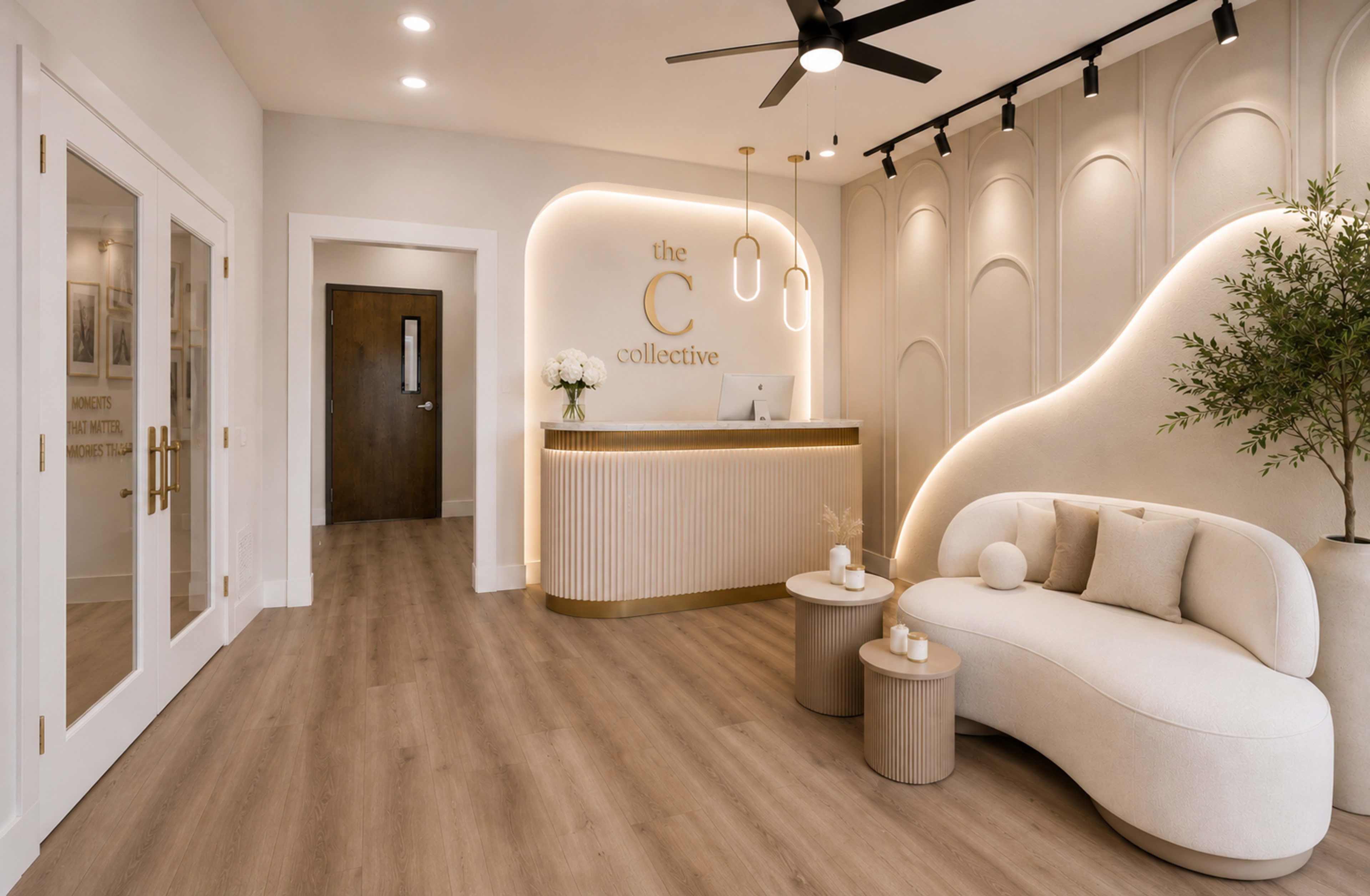 The image shows a modern, well-lit reception area featuring a curved desk with an illuminated sign, a cozy seating arrangement, and decorative elements such as a small plant and stylish round tables.